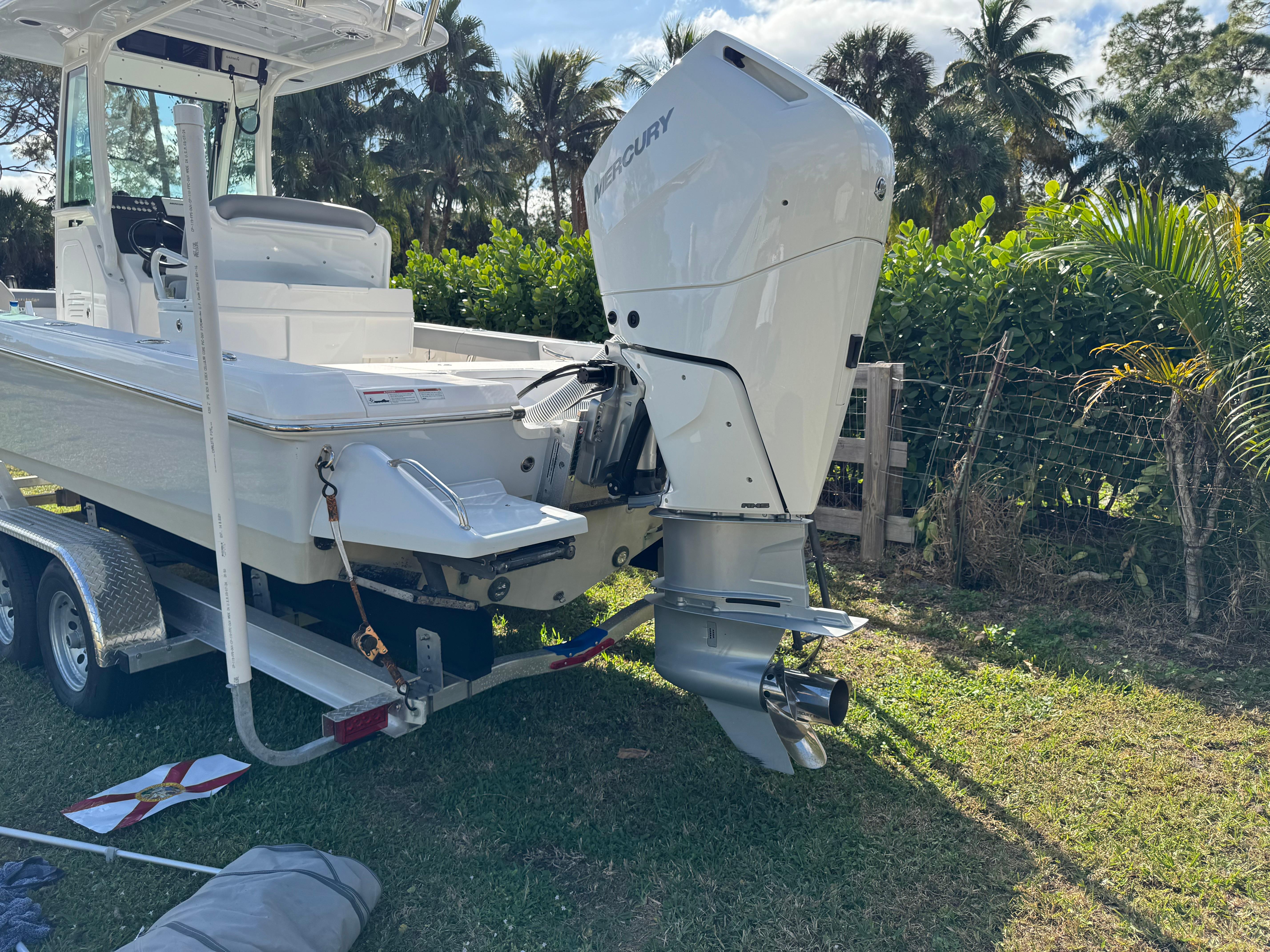 2024 Everglades 253 Center Console boat on trailer, surrounded by lush greenery.
