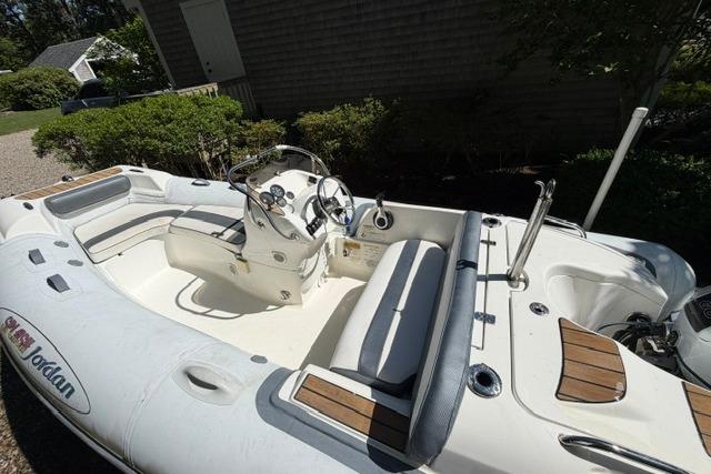2016 Walker Bay Generation 450 DLX inflatable boat with seating and steering console.