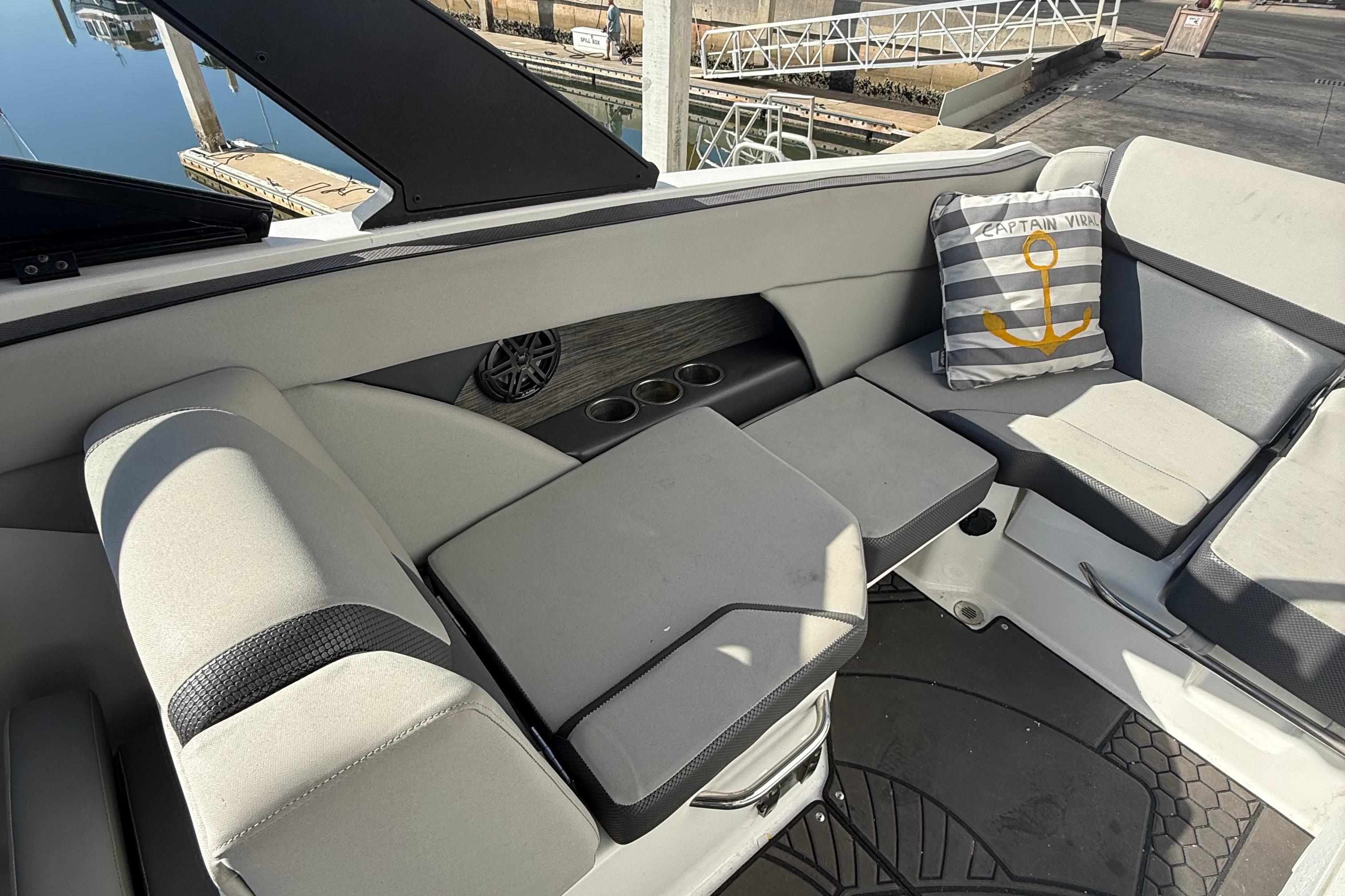 2021 Scarab 255 ID boat interior with cushioned seating and nautical-themed pillow.