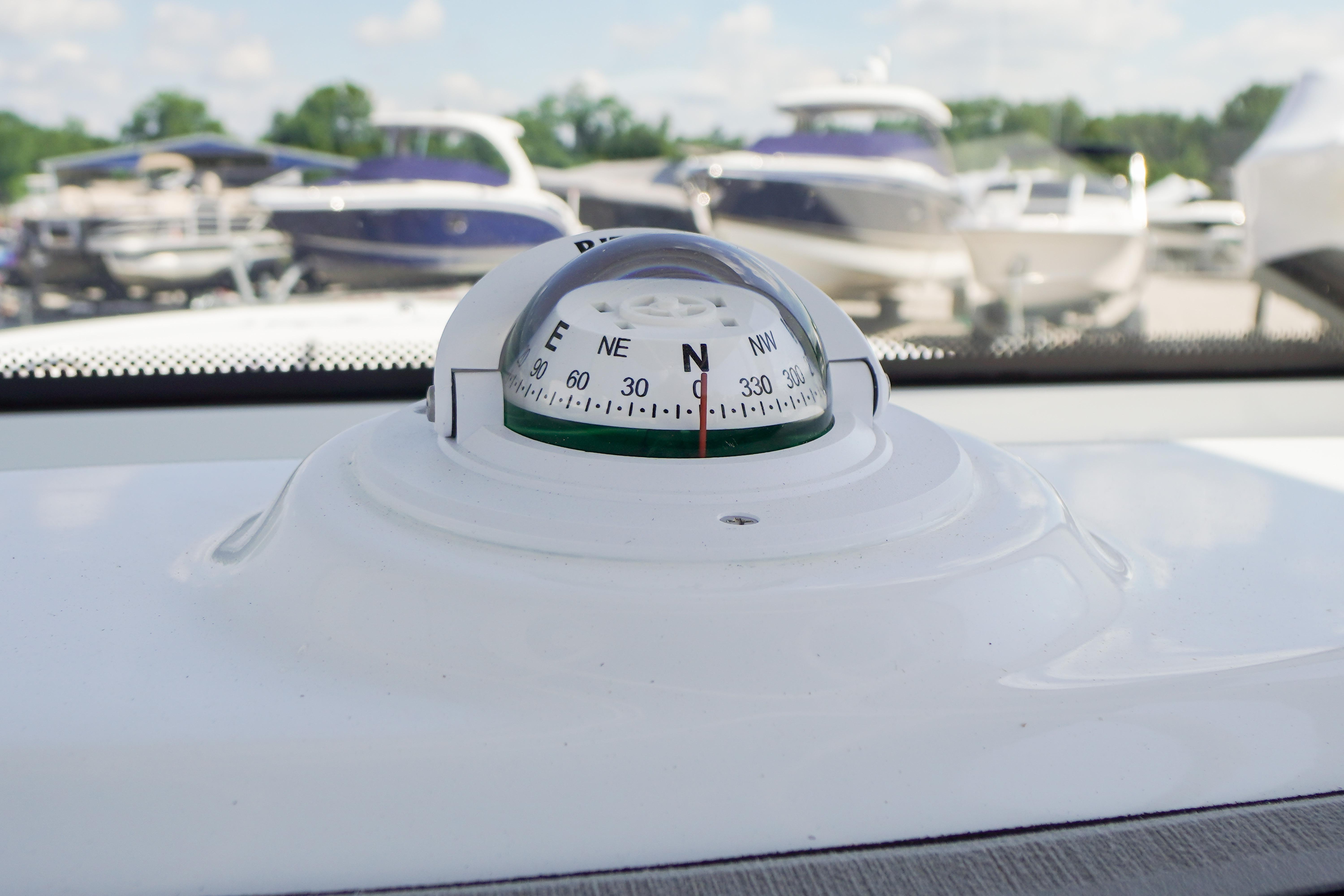 Compass on 2026 Tidewater 220 CC Adventure boat, with blurred marina background.