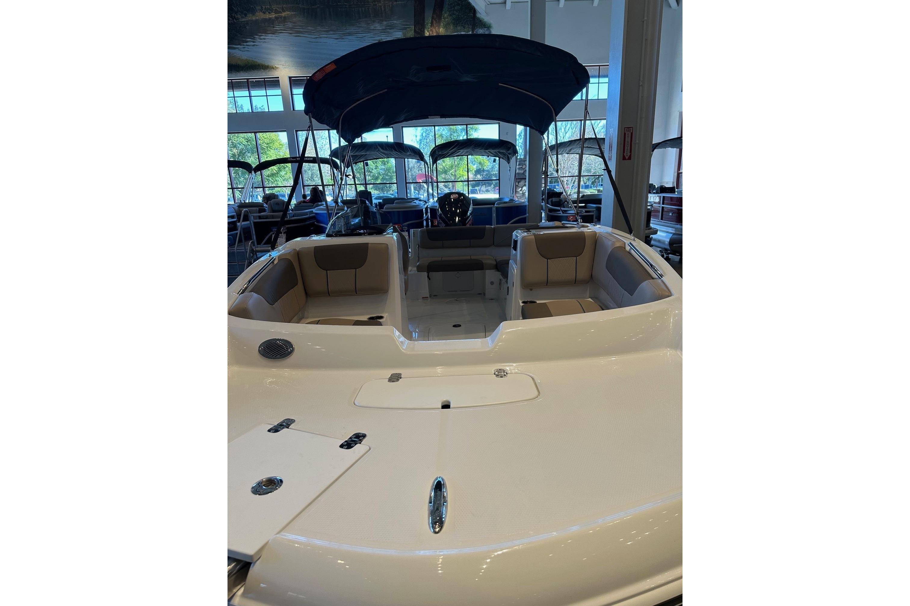 2026 Tahoe 1950 boat interior with seating, displayed in a showroom.