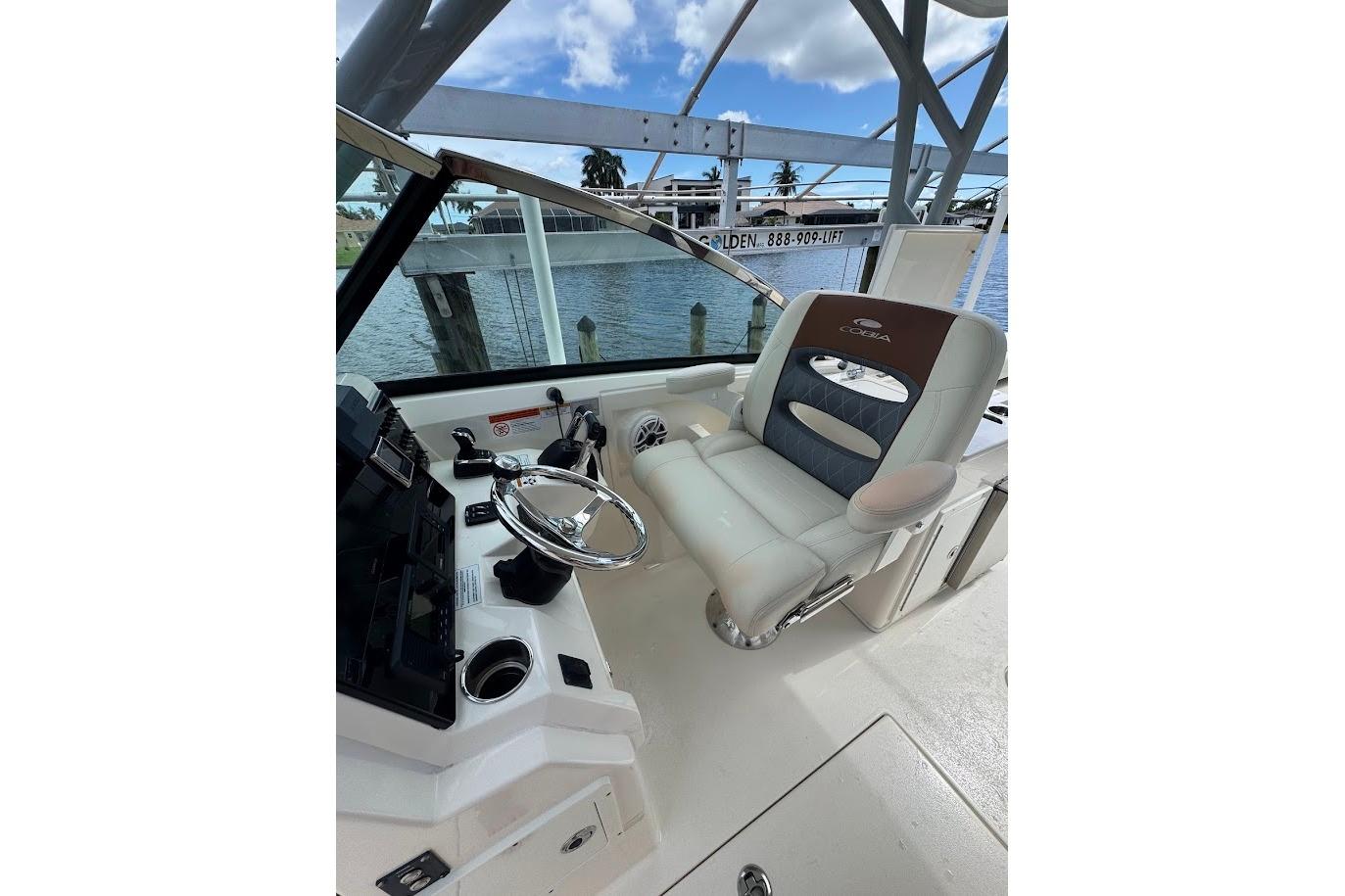 2020 Cobia 280 Dual Console boat interior with steering wheel and captain's chair.
