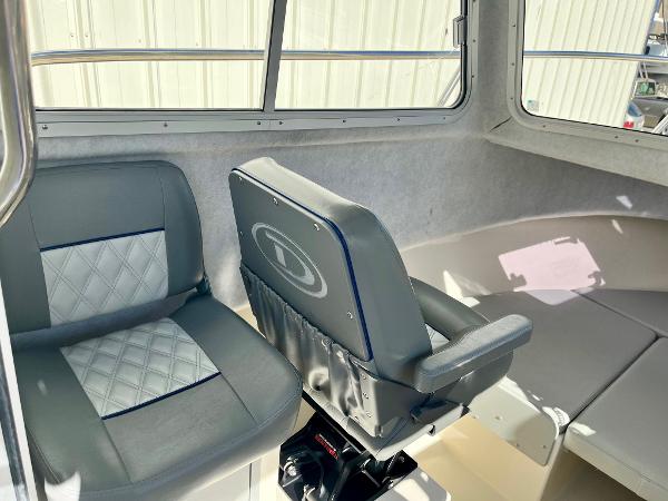 Interior of 2023 Defiance Admiral 220 EX boat with cushioned seating.