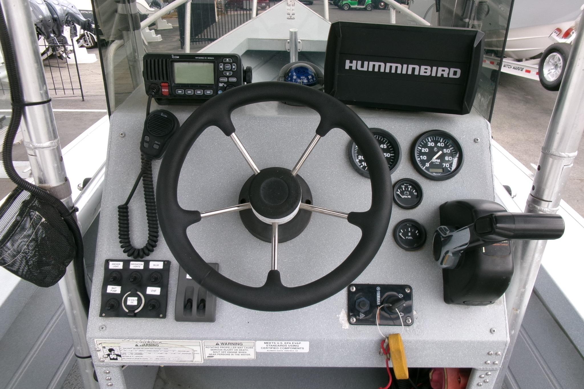 2017 Klamath Bayrunner 19 Baja boat dashboard with steering wheel, gauges, and Humminbird electronics.