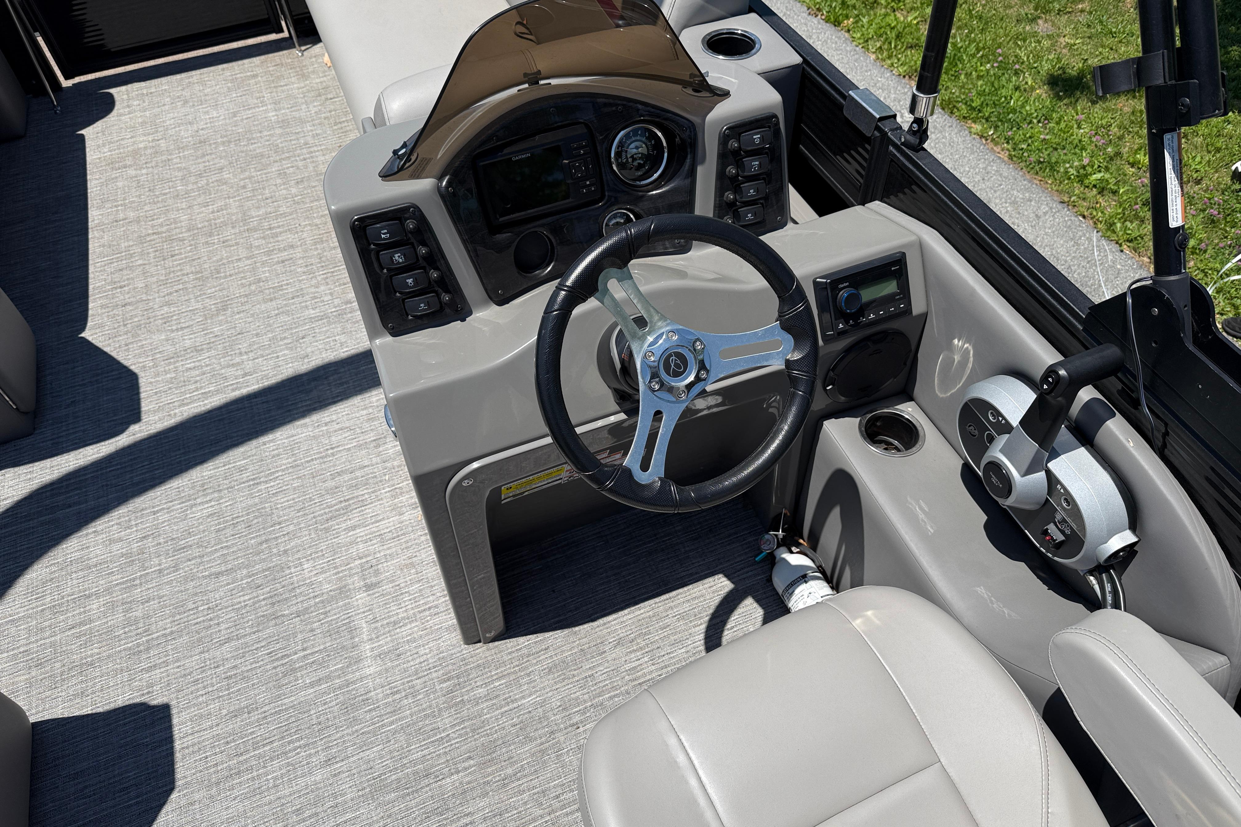2023 Apex 818 boat dashboard with steering wheel, controls, and seating on a sunny day.