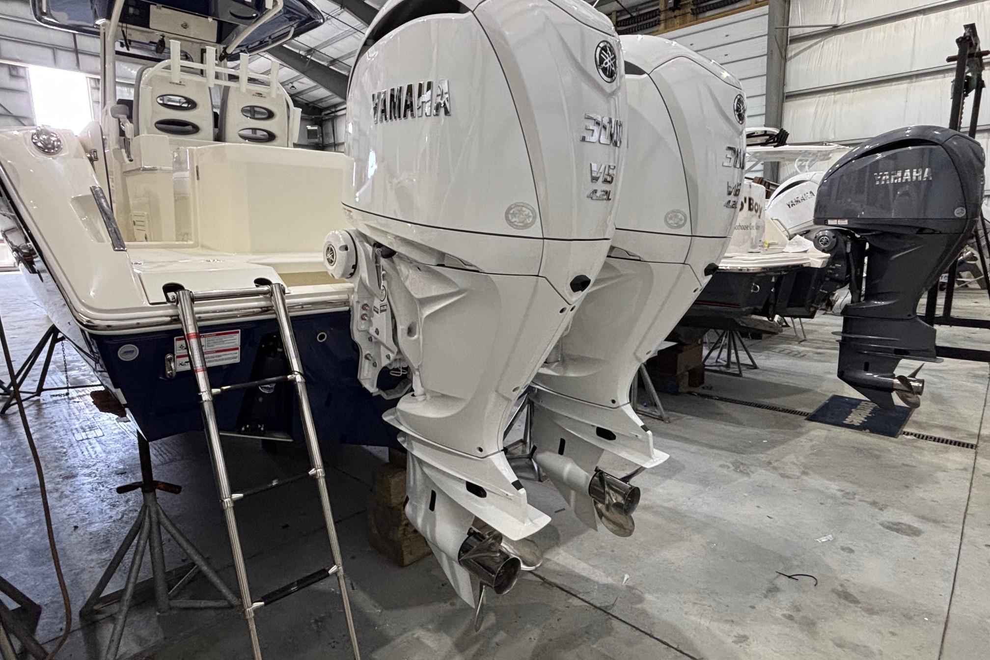 2026 Cobia 285 Open Center Console with twin Yamaha outboard engines in a storage facility.