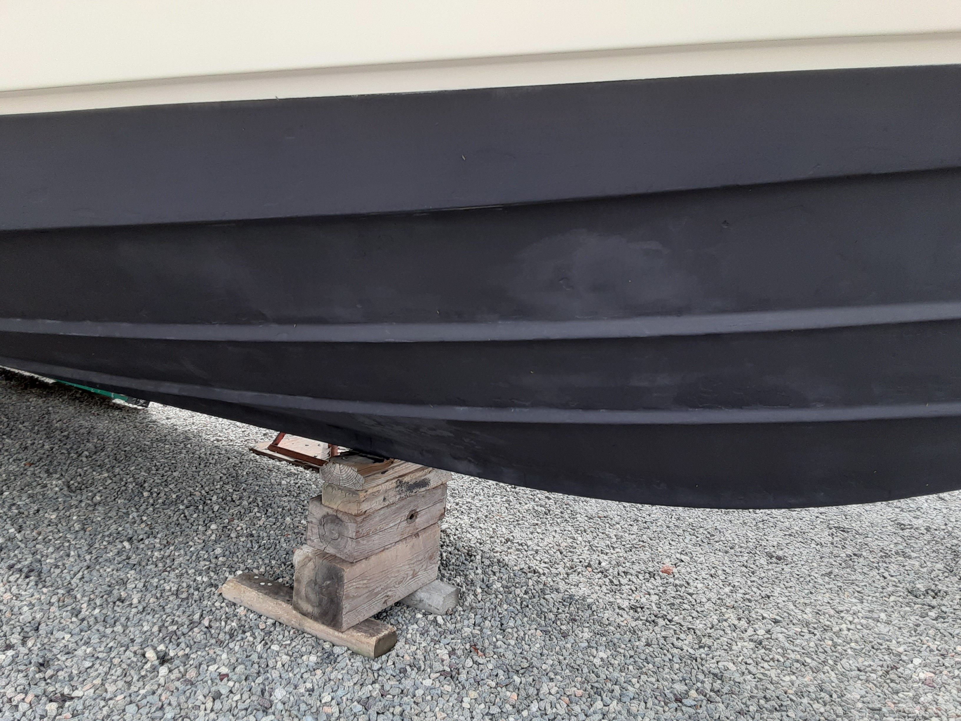 Hull of a 1985 Tiara Yachts 3100 Open on gravel.