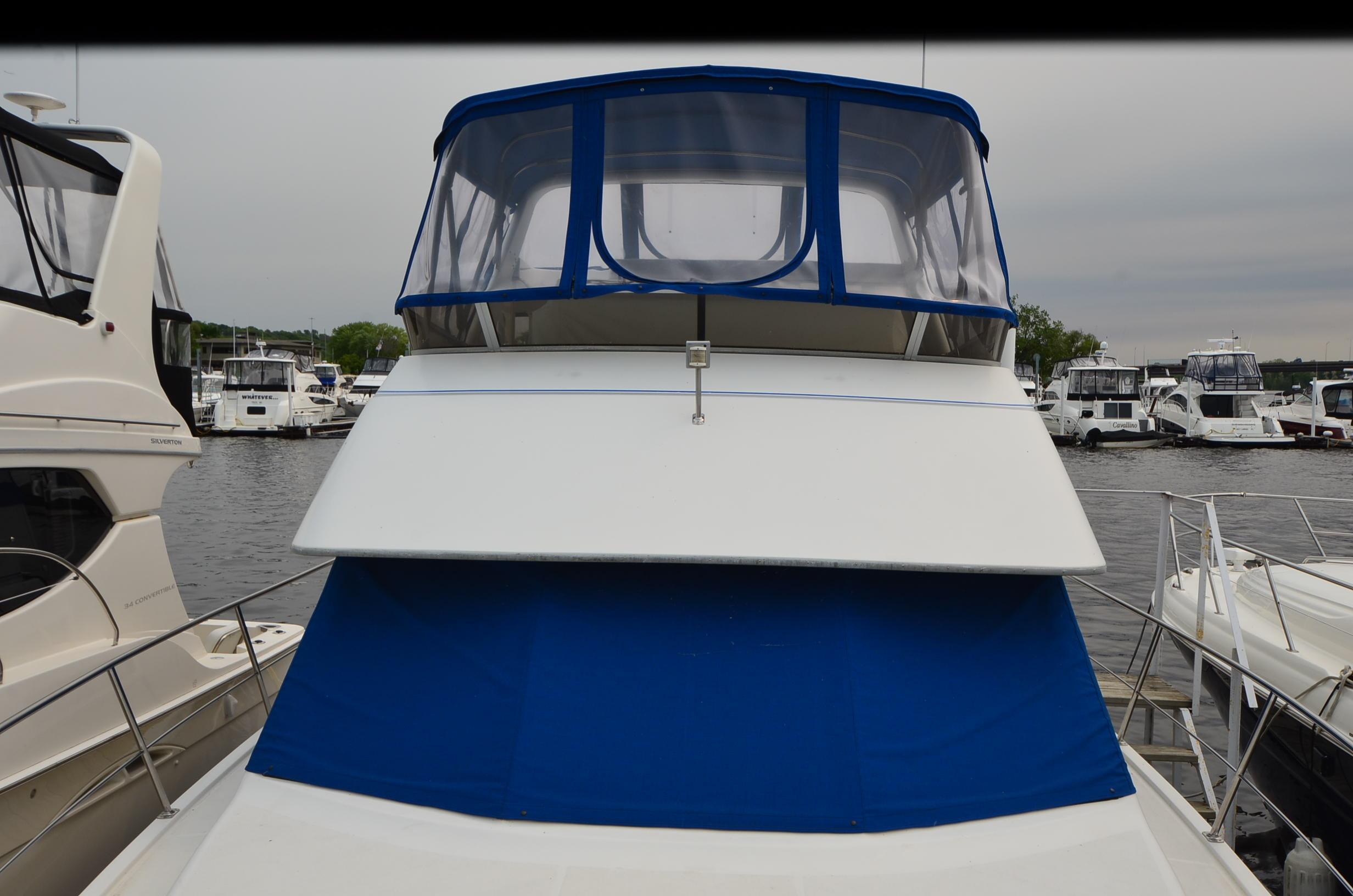 1993 Carver 350 Aft yacht with blue canopy docked at marina.