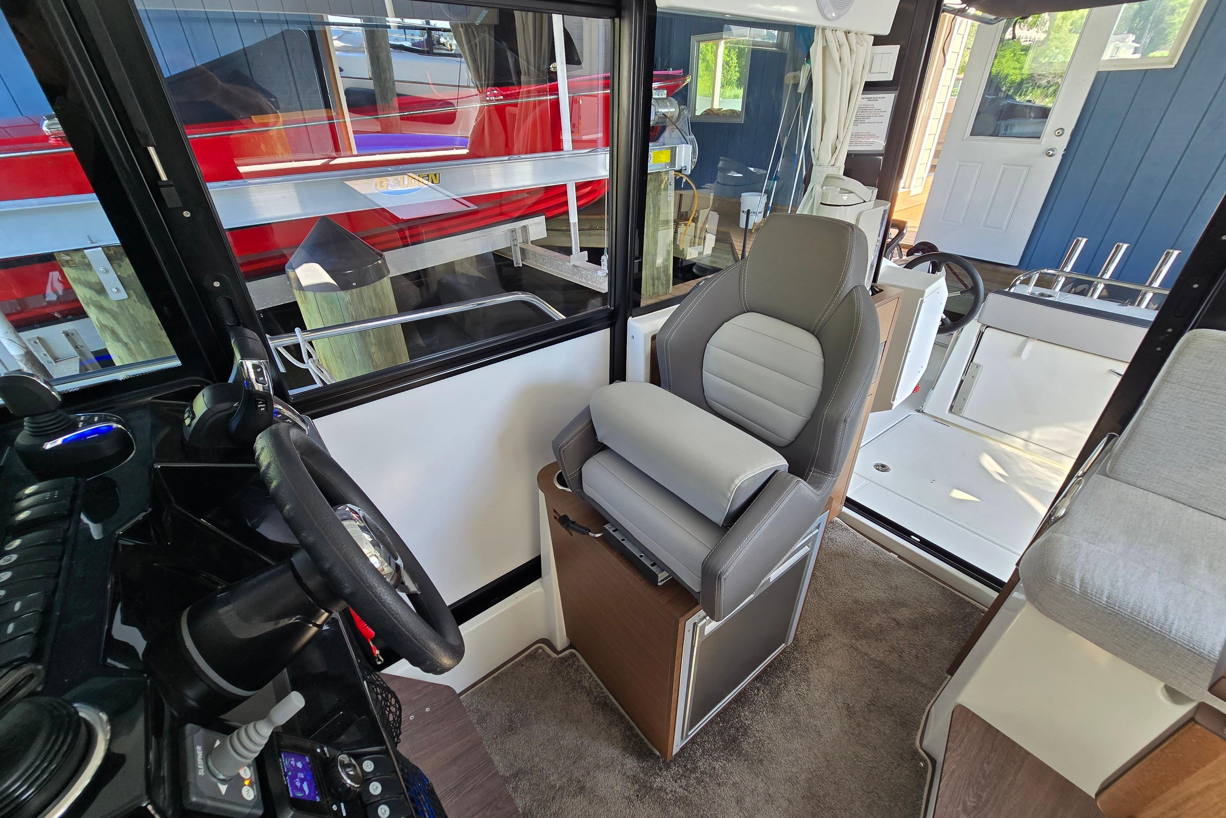 Interior of a Jeanneau NC Sport 895 with a gray seat and helm station.