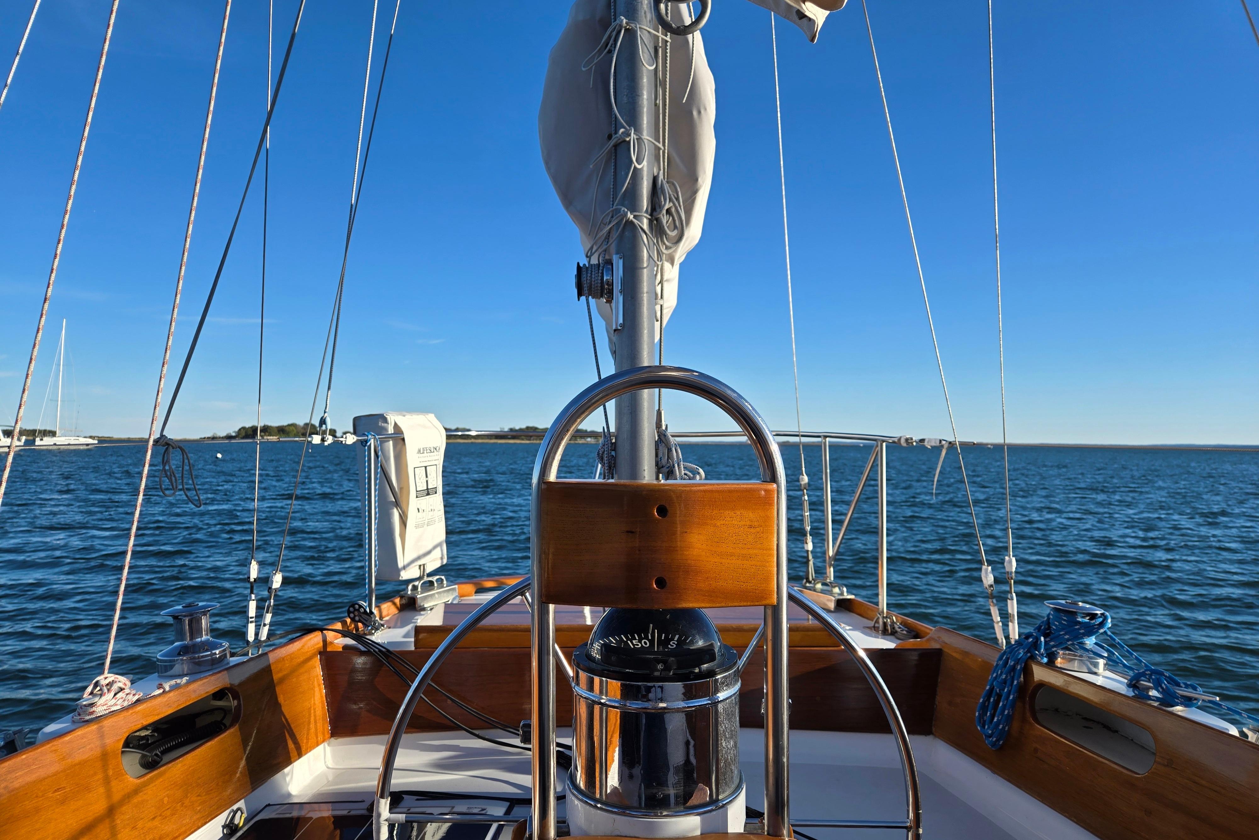 1970 Hinckley Bermuda 40 sailboat cockpit with ocean view and clear blue sky.