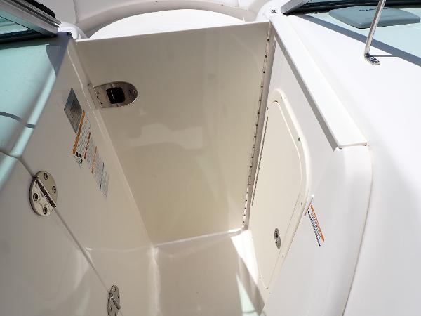 2011 Chaparral 287 SSX boat interior compartment with white finish and metal hinges.