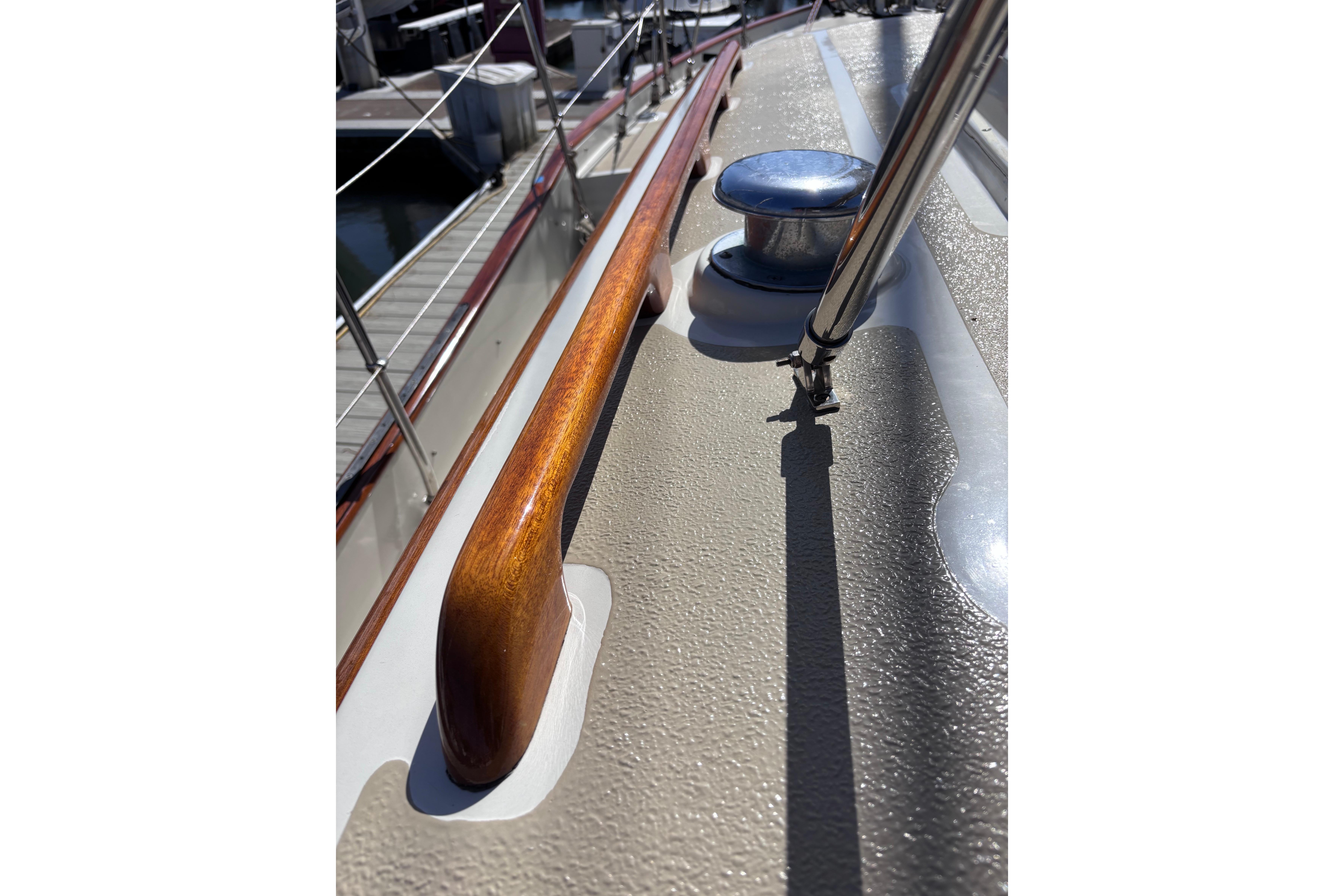 Close-up of 1978 Swift 33 sailboat deck with polished wood and metal fittings.