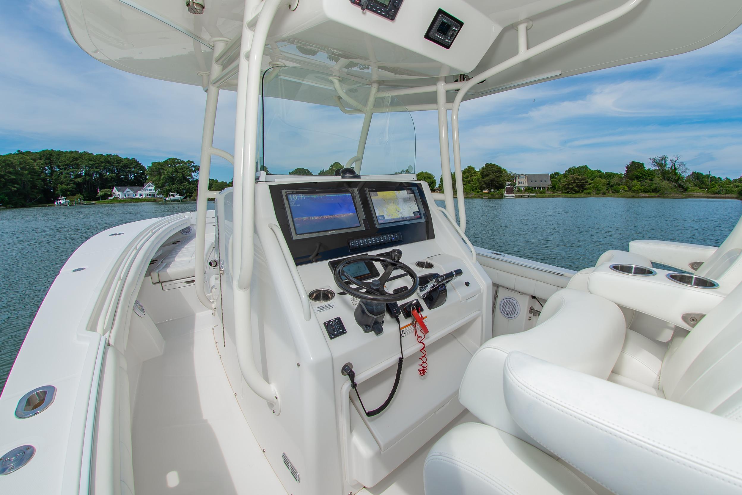 2019 Regulator 31 boat cockpit with dual screens and steering wheel on calm water.