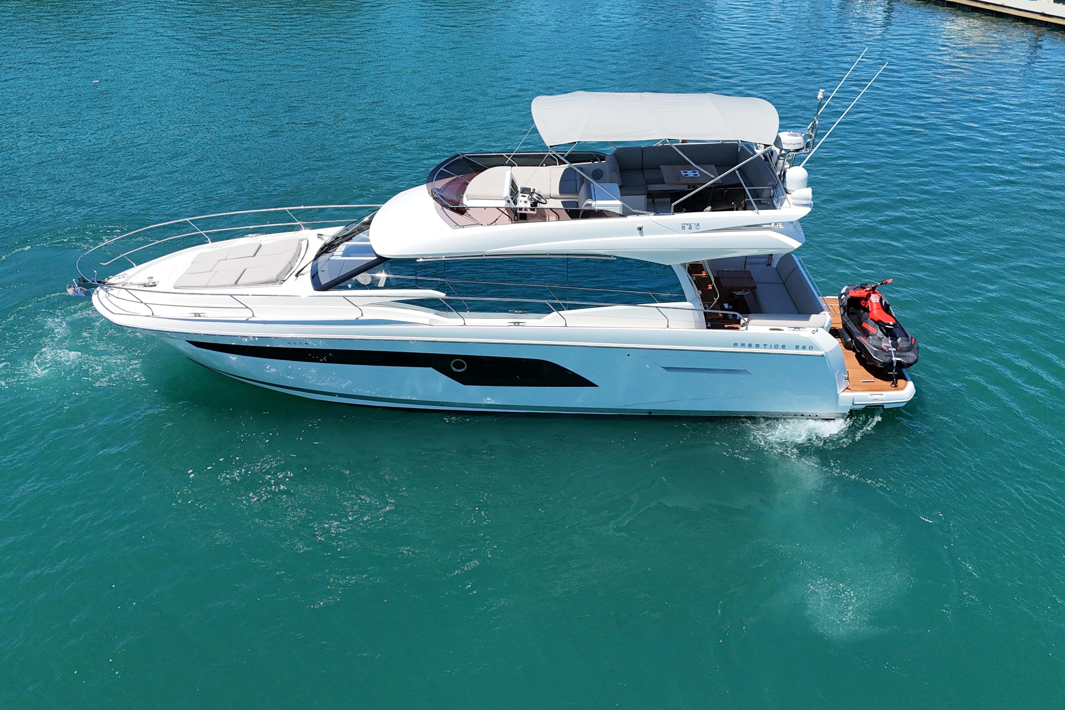 2022 Prestige 520 yacht cruising on clear blue water.