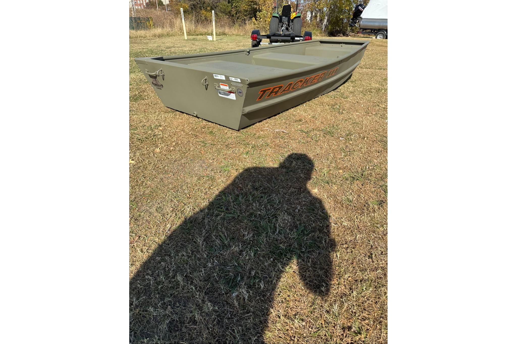 2026 Tracker Grizzly 10 Jon boat on grass, shadow in foreground.