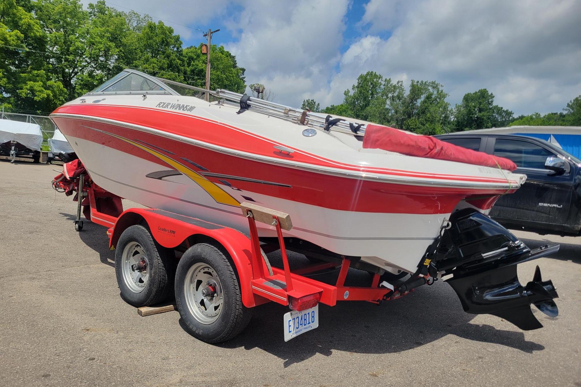 2007 Four Winns 200 Horizon boat on a red trailer, parked outdoors.