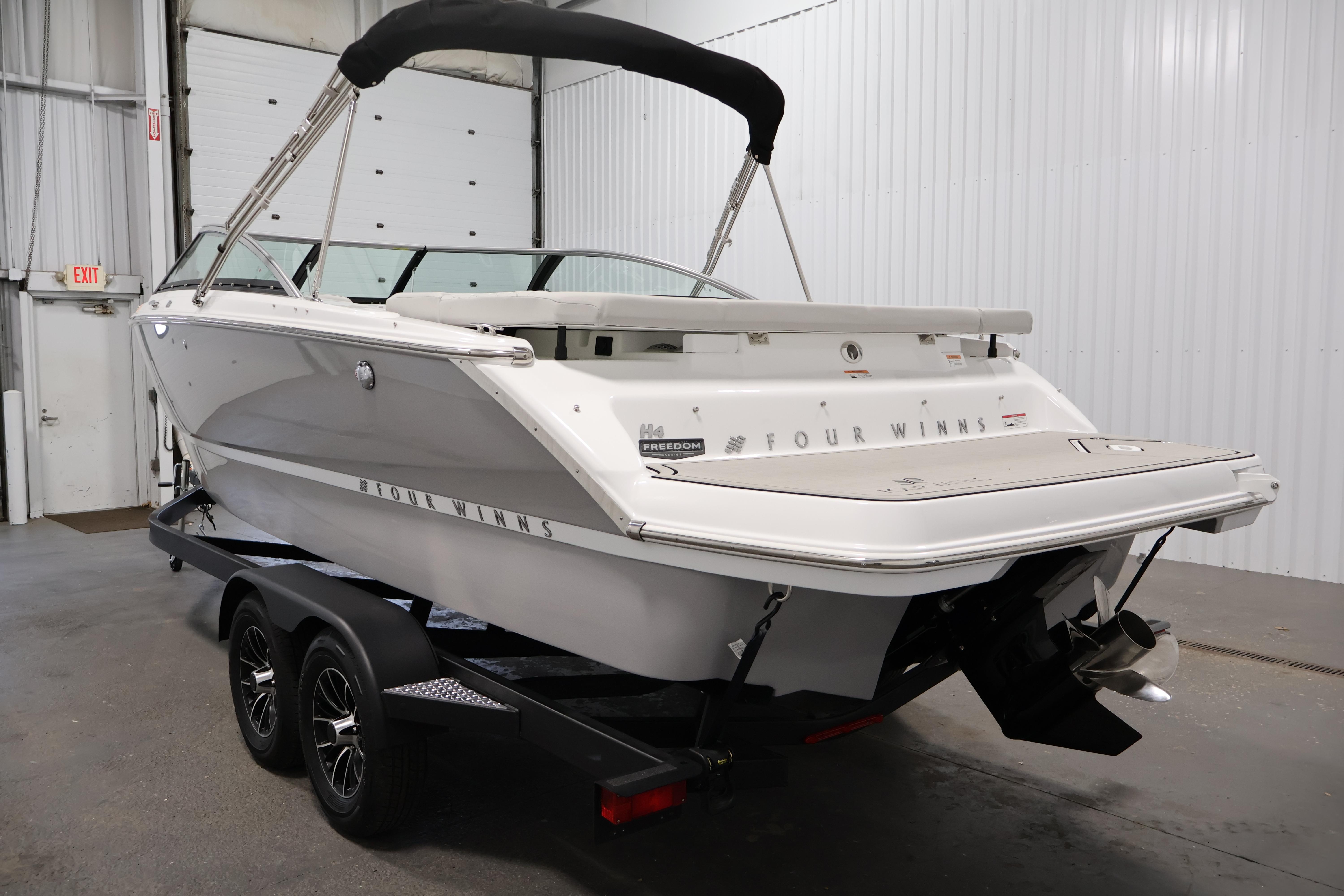2026 Four Winns H4 Freedom boat on trailer in indoor storage.