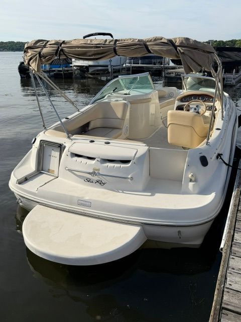 A 2001 Sea Ray 210 Sundeck docked. It features a sunshade and beige seating.