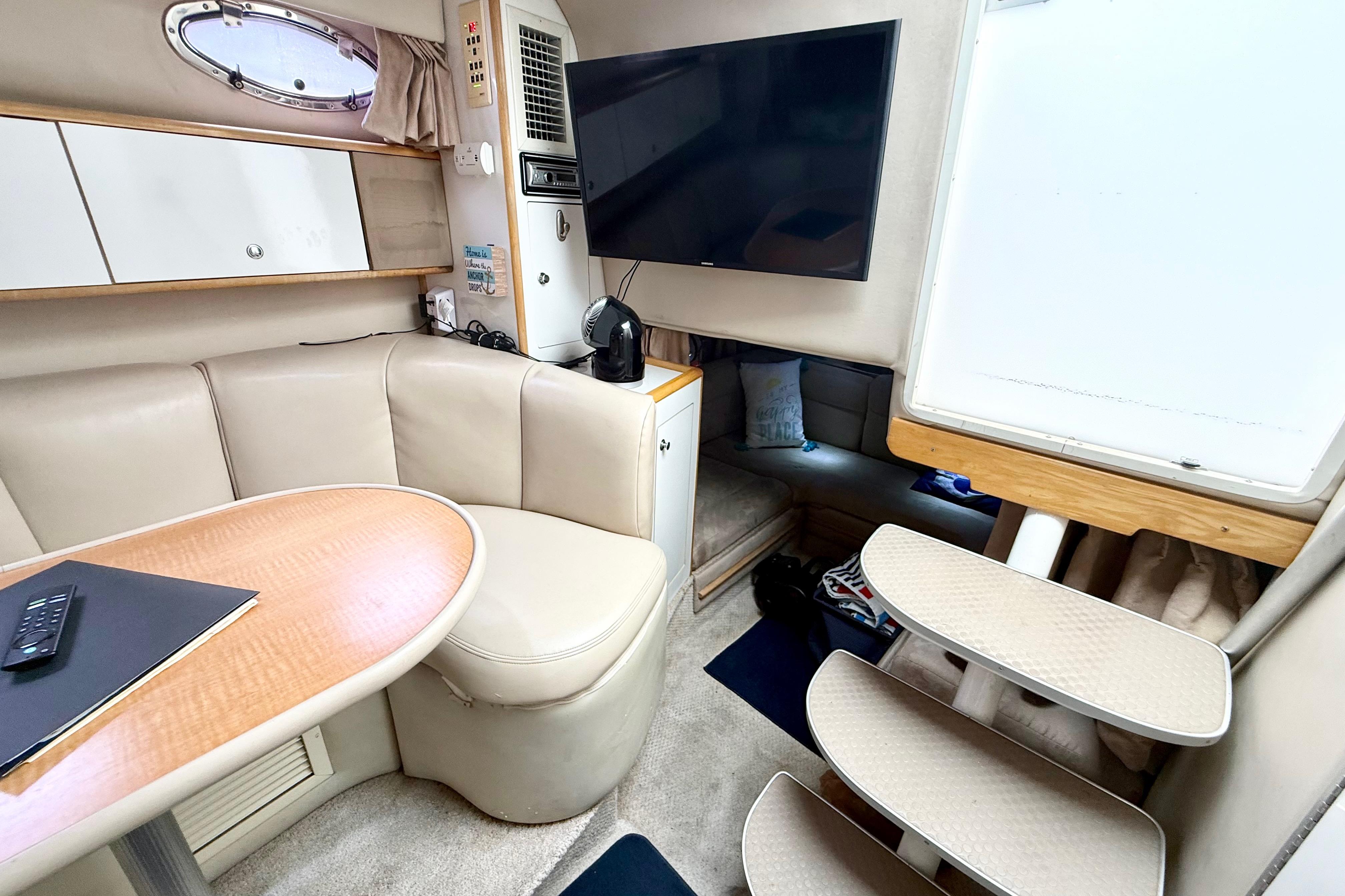 1999 Chaparral Signature 300 cabin interior with seating, table, and TV.