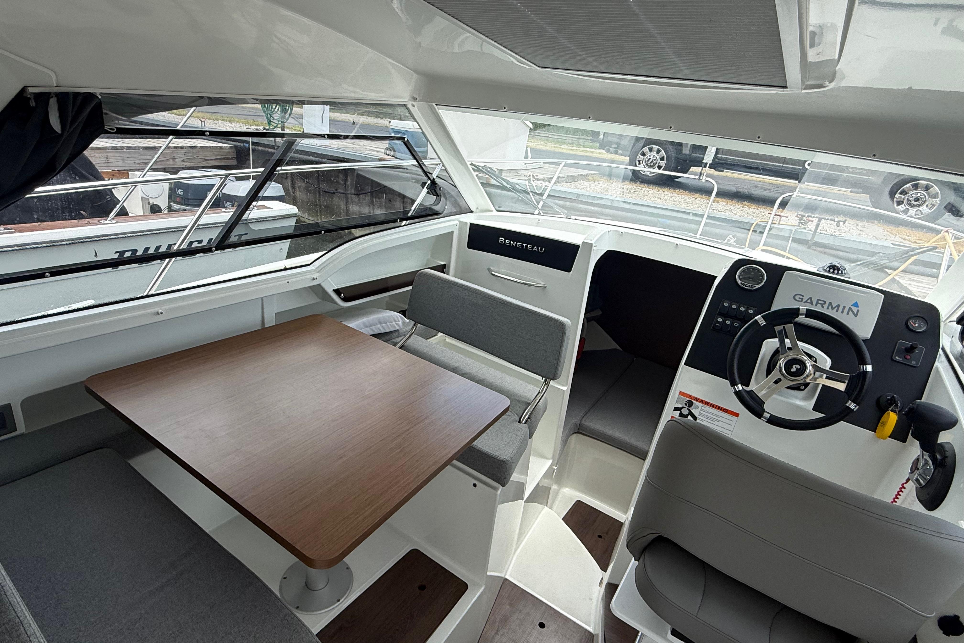 Interior of 2019 Beneteau Antares 23 boat with helm, seating, and table.