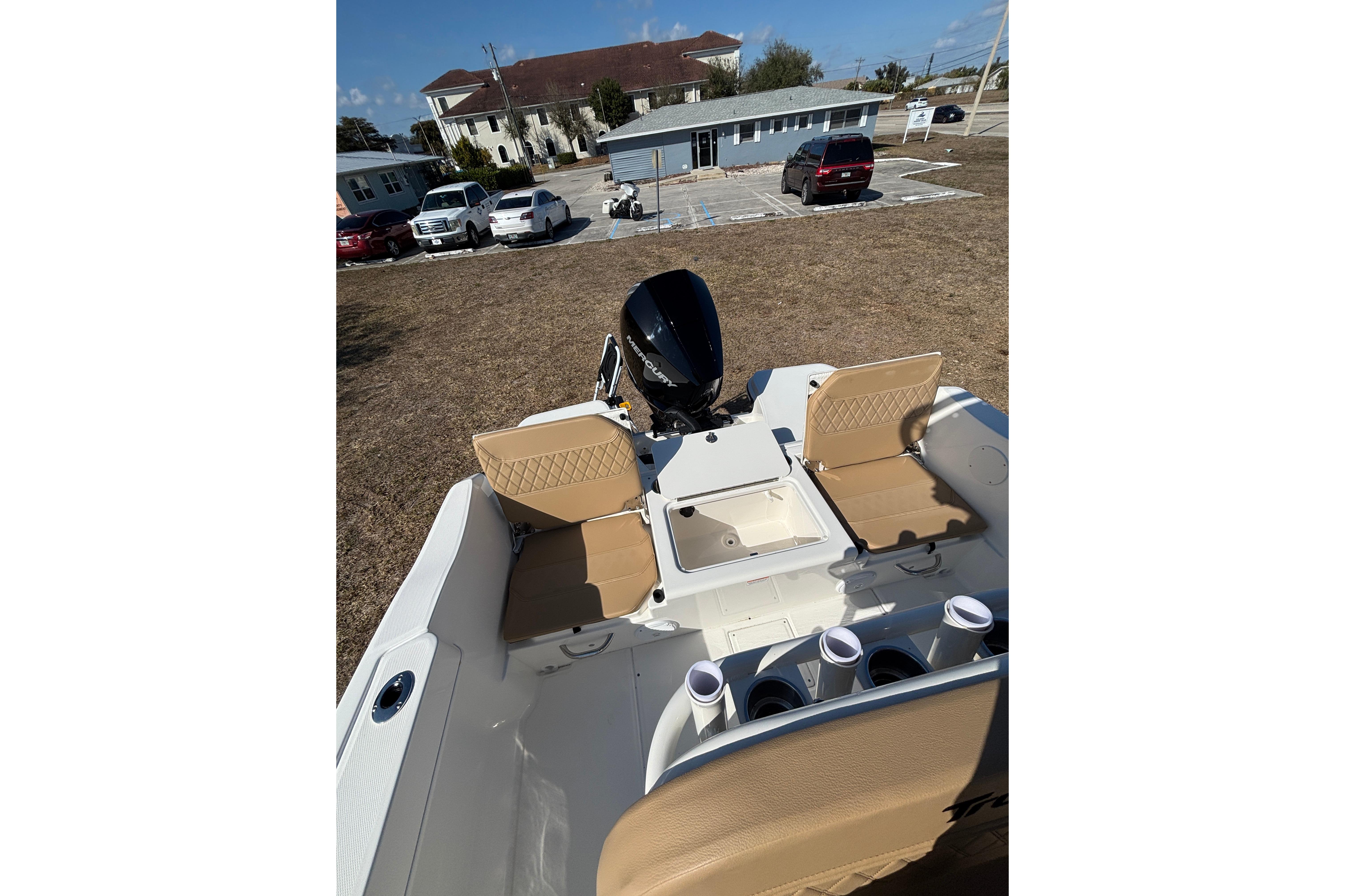 2026 Bayliner Trophy T22CC boat interior with seating and motor, parked outdoors.