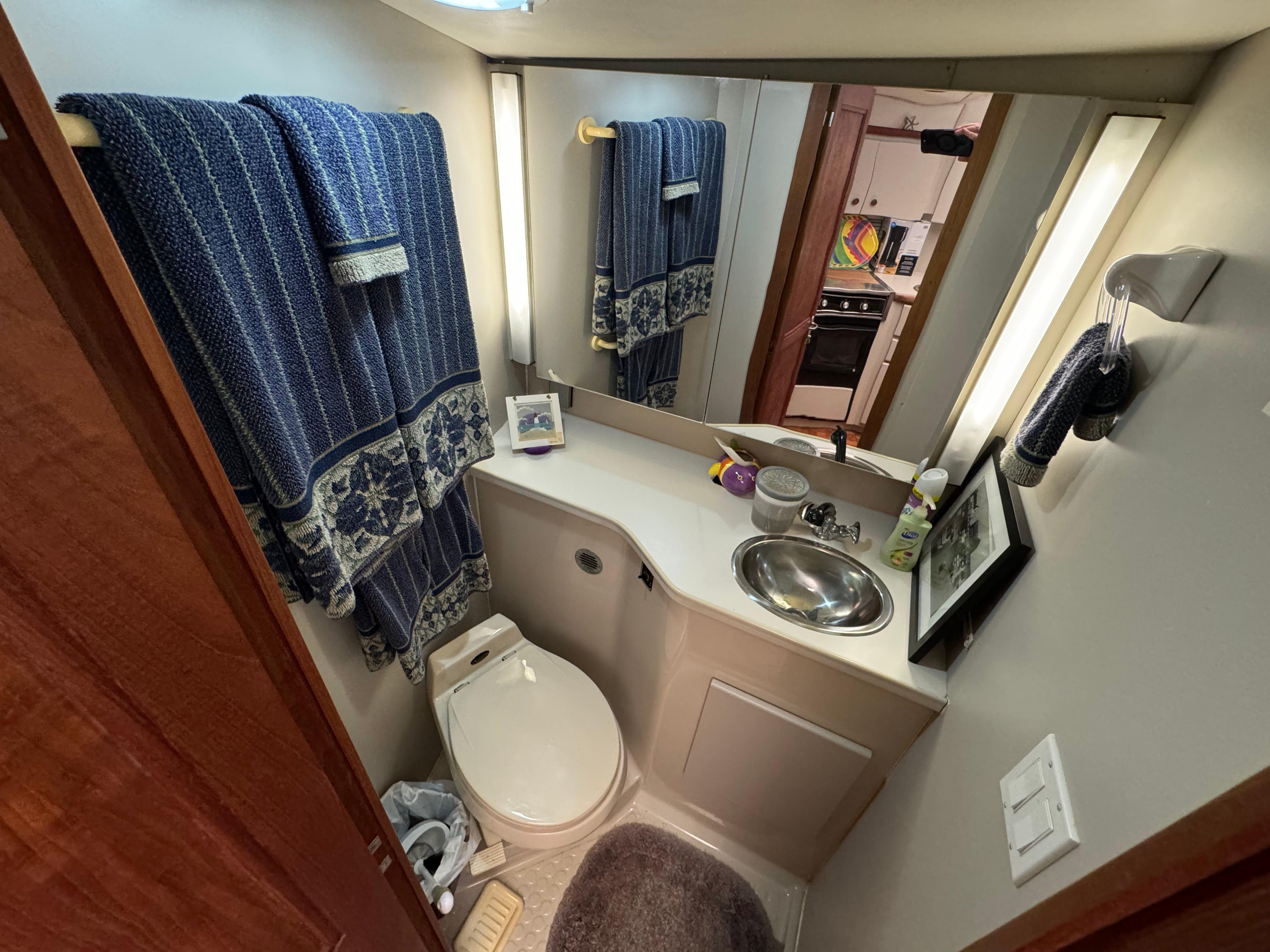 1991 Carver 33 Aft Cabin bathroom with sink, toilet, and blue towels.