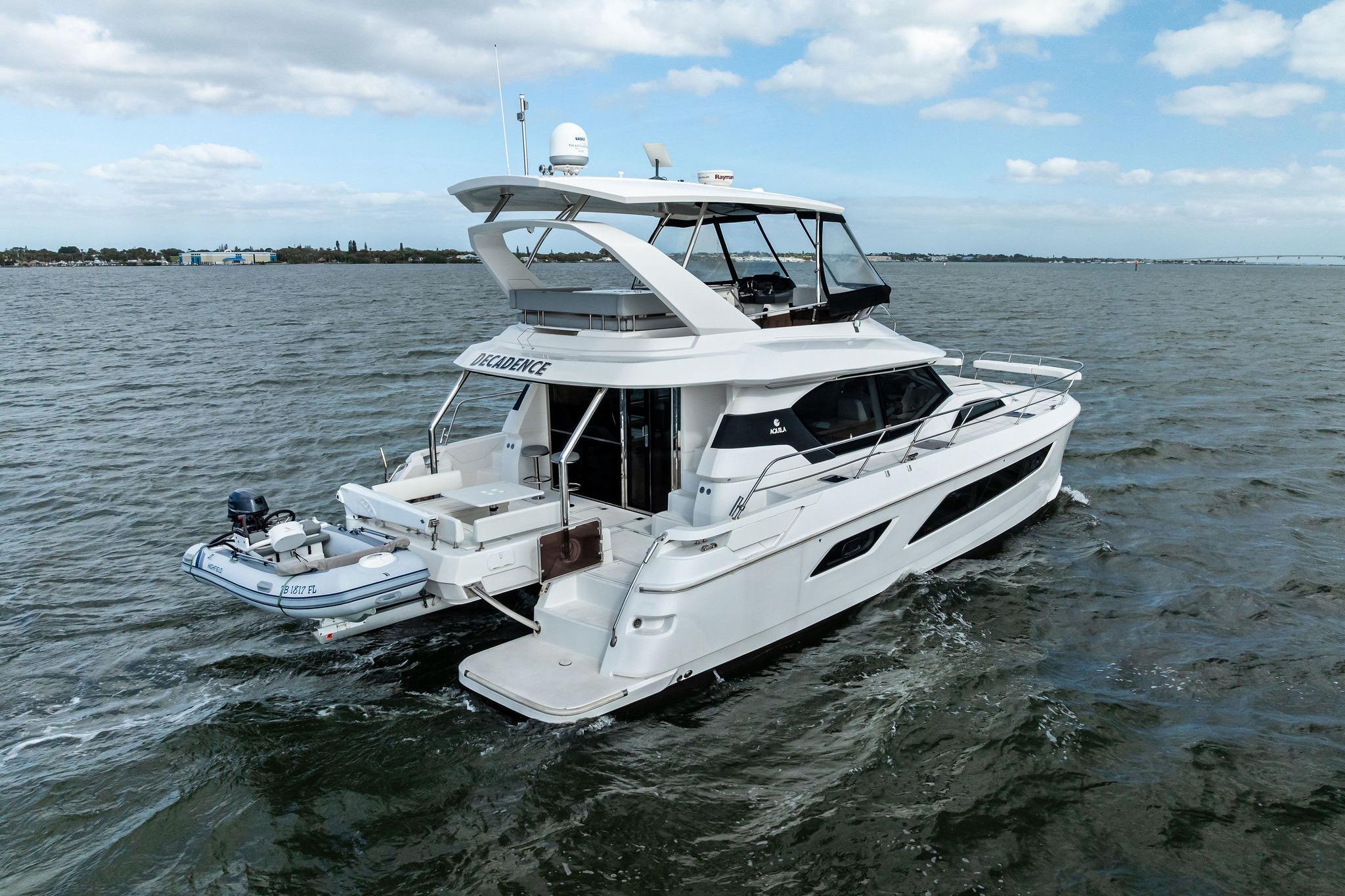 2021 Aquila 44 Yacht cruising on open water under a partly cloudy sky.