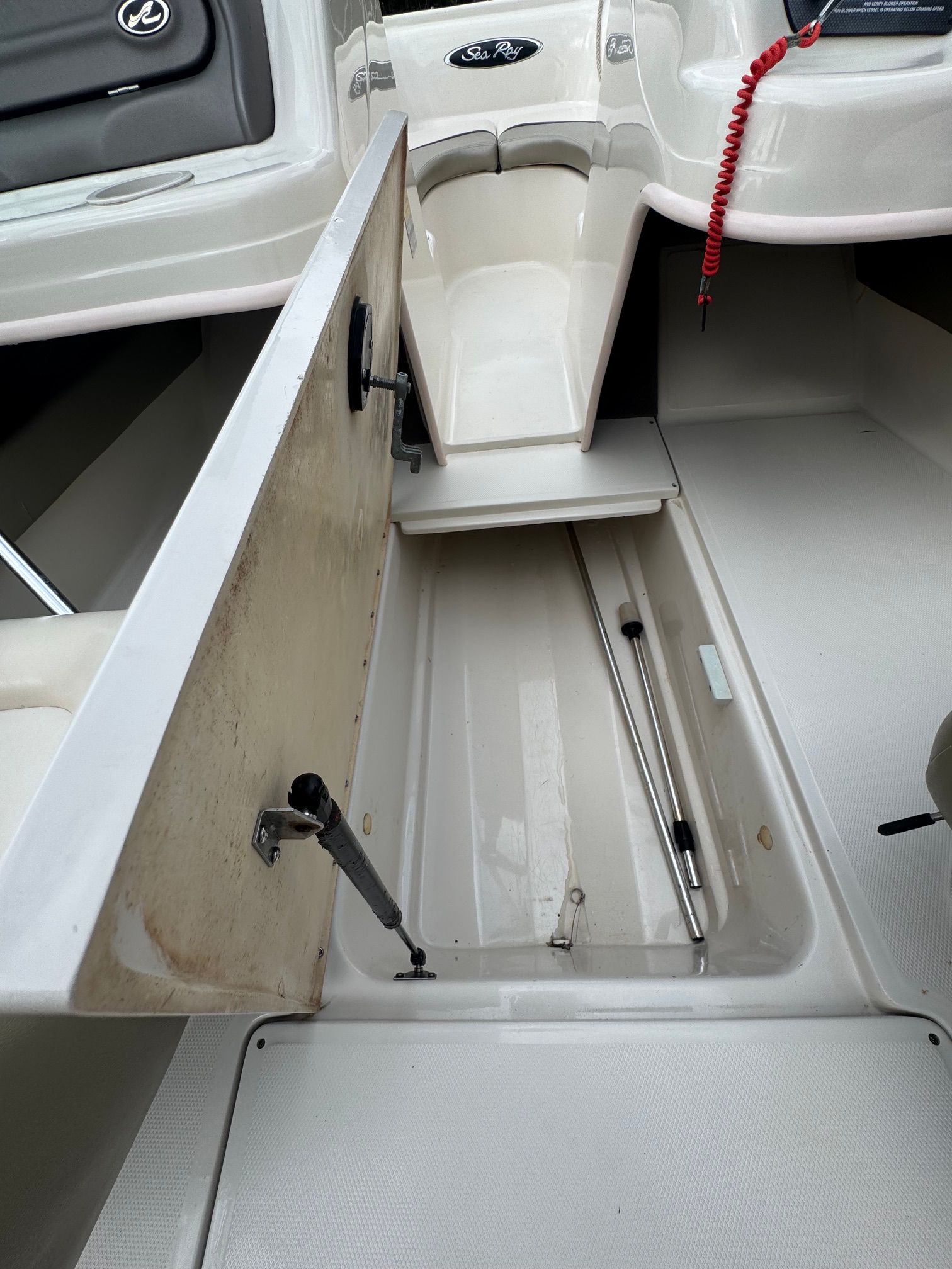 Open storage compartment in the floor of a 2005 Sea Ray 185 Sport boat.