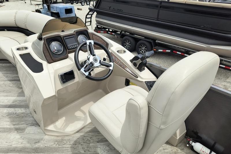 2017 Manitou 25 Oasis SE boat interior with steering wheel and dashboard controls.