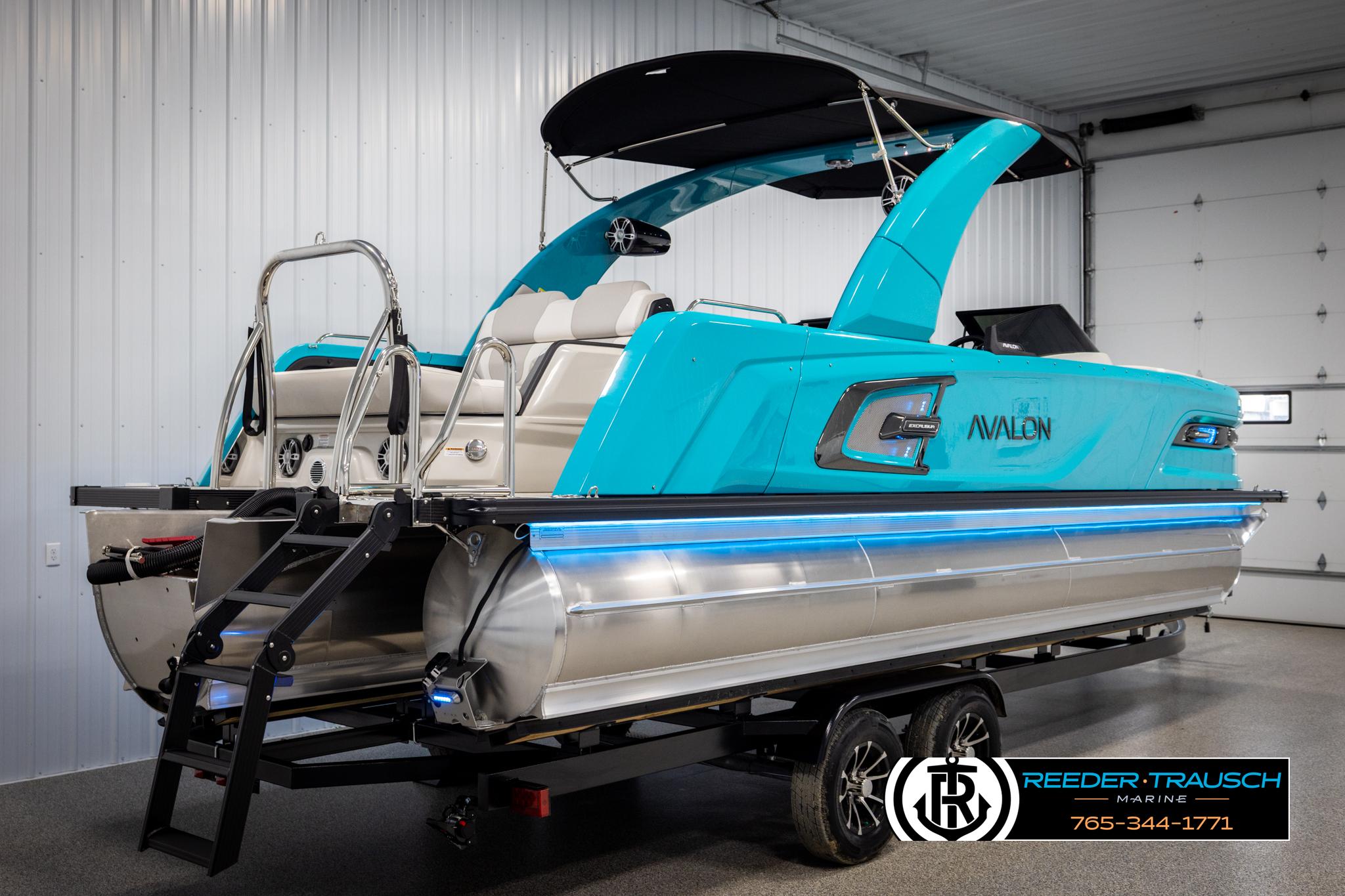 2025 Avalon 2585 Excal VRBW pontoon boat in a showroom with blue accents.
