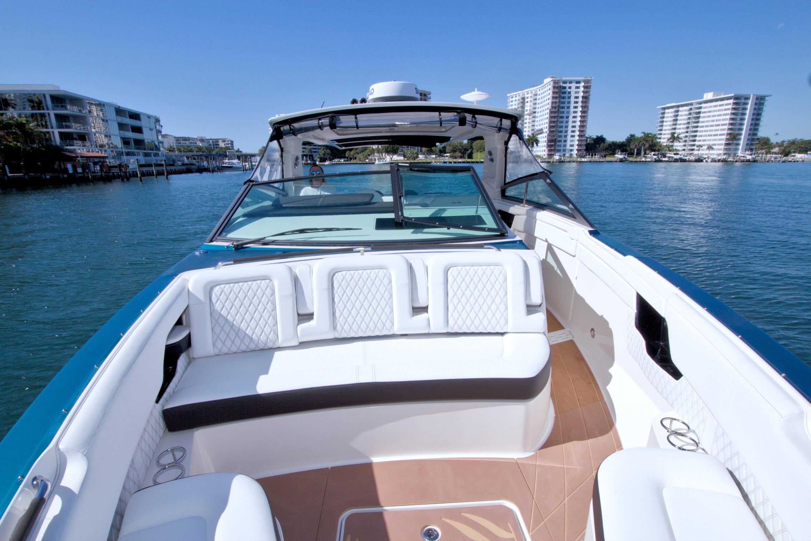 2021 Sea Ray SLX 400 Outboard cruising on a sunny day near waterfront buildings.