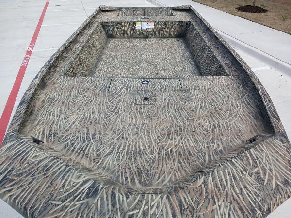 2025 Tracker GRIZZLY 1860 Utility boat with camouflage design on concrete surface.