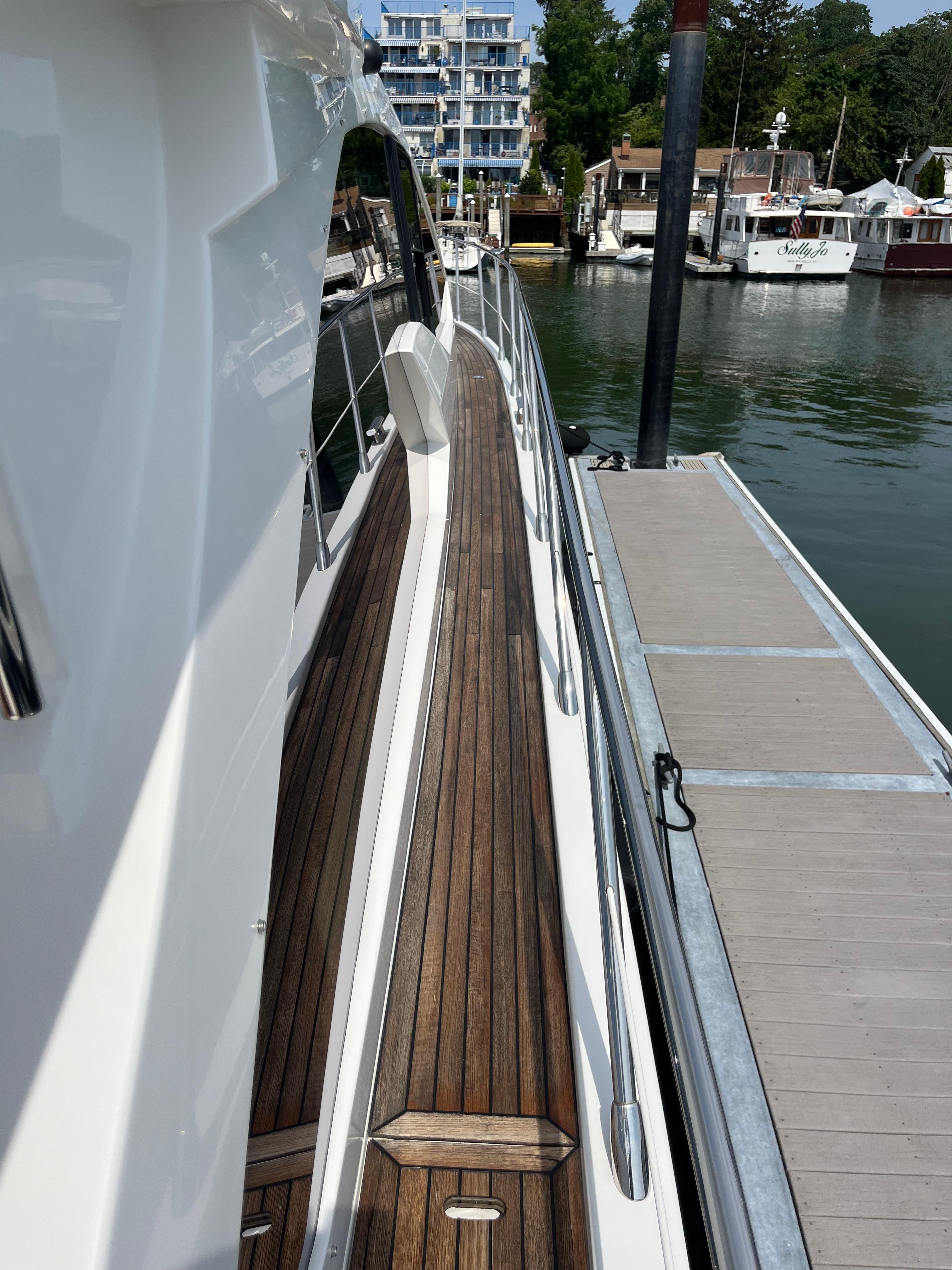 2014 Azimut 55S yacht docked, showcasing sleek design and wooden deck.