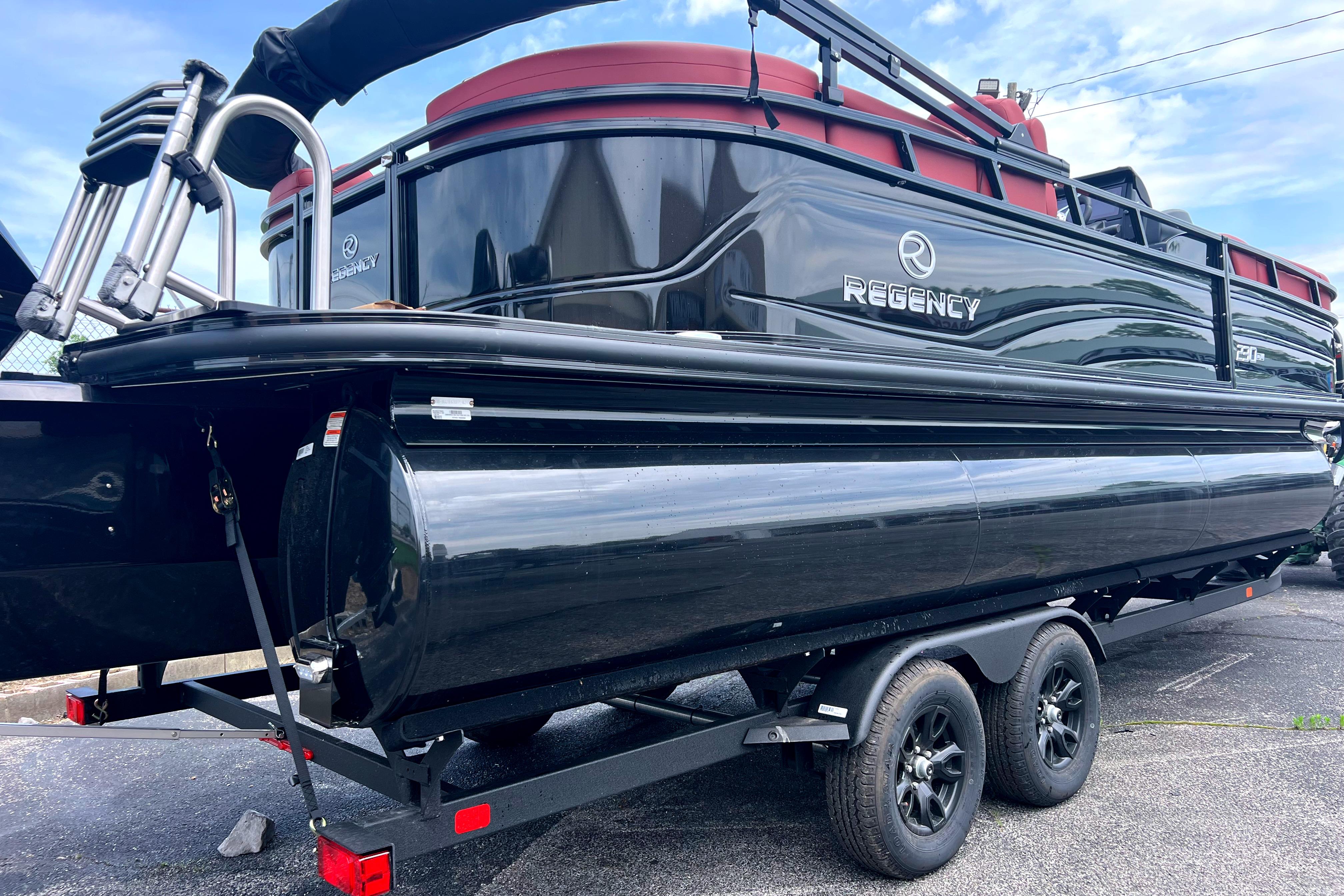 2026 Regency 230 DL pontoon boat on trailer, sleek black design.