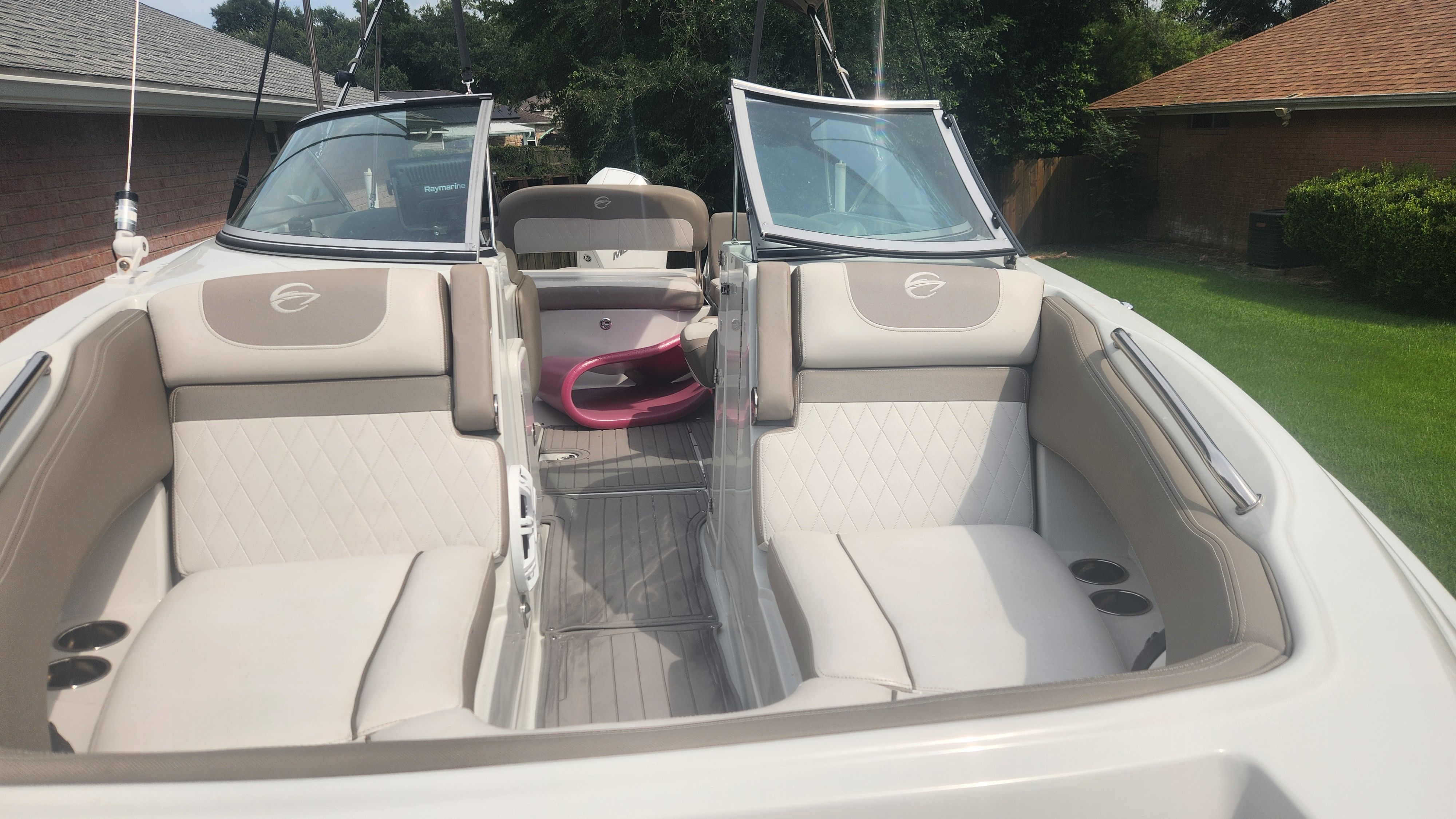 The image shows the cockpit of a 2019 Crownline Eclipse E235 XS with beige seating.