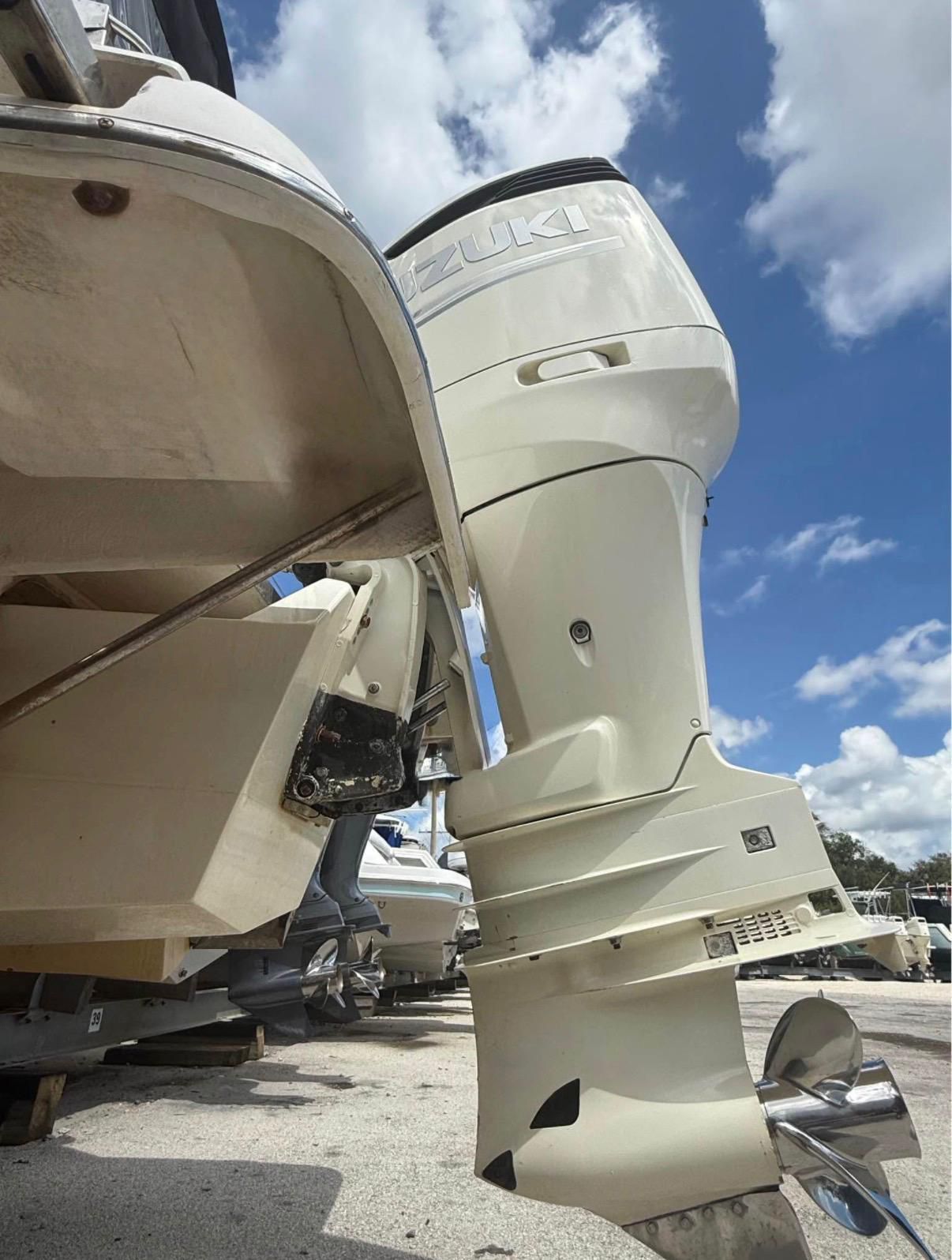 A Suzuki outboard motor on a Regal 2565 Window Express boat, resting on a dry dock.