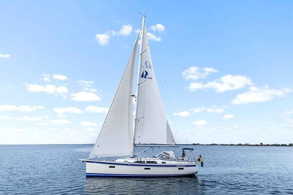 2022 Hallberg-Rassy 400 sailboat on calm water under blue sky.