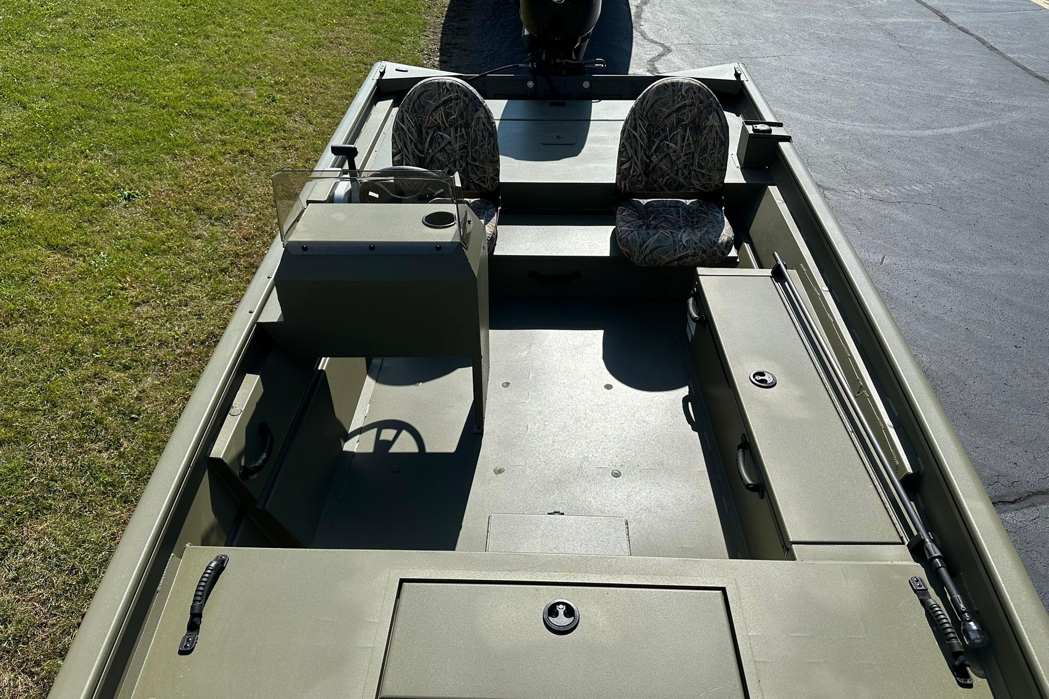 2026 Lowe Roughneck 1860SC boat interior with two camo seats, steering console, and storage compartments.