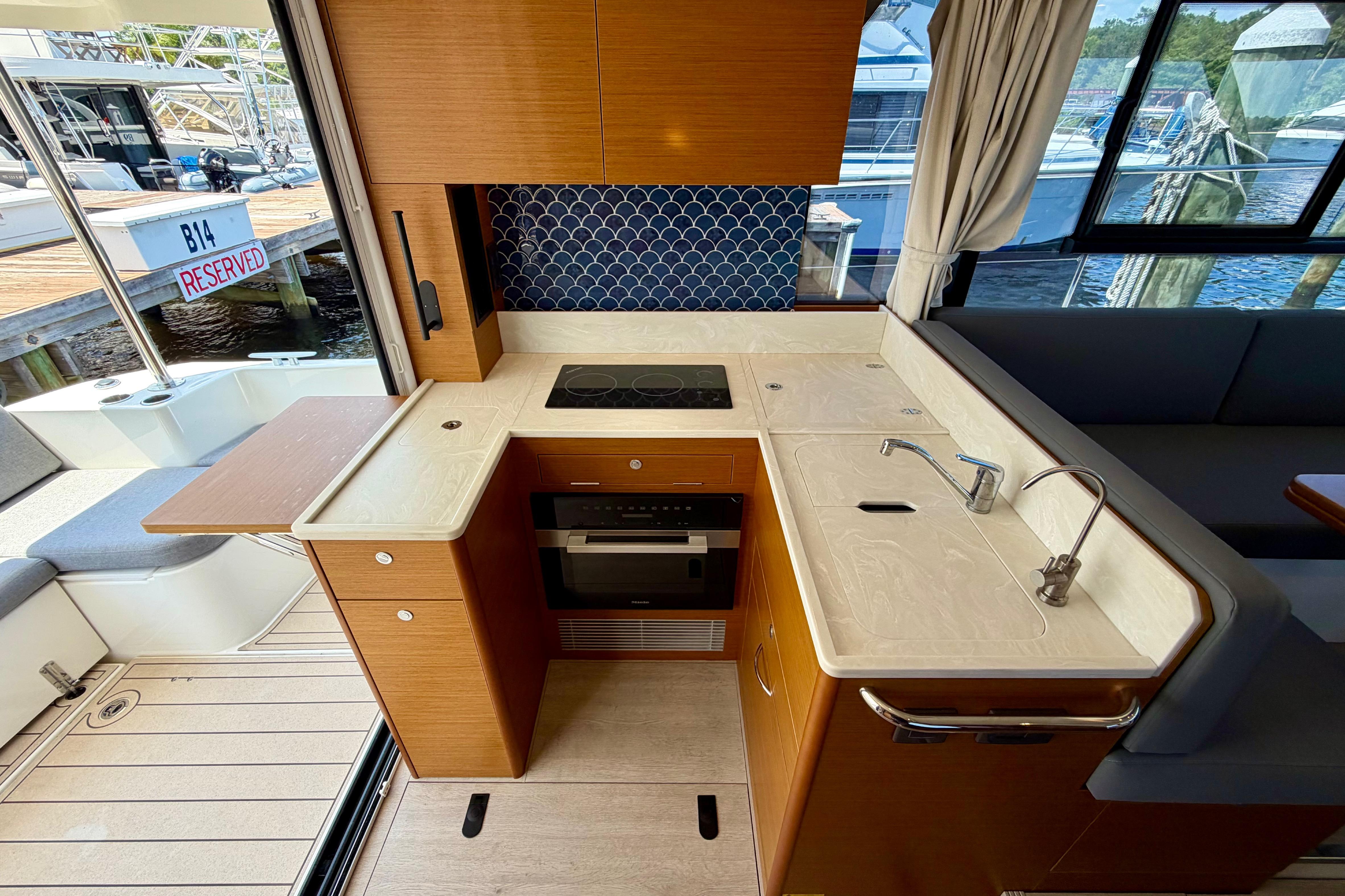 Modern kitchen in 2025 Beneteau Swift Trawler 41 Fly, featuring sleek countertops and appliances.