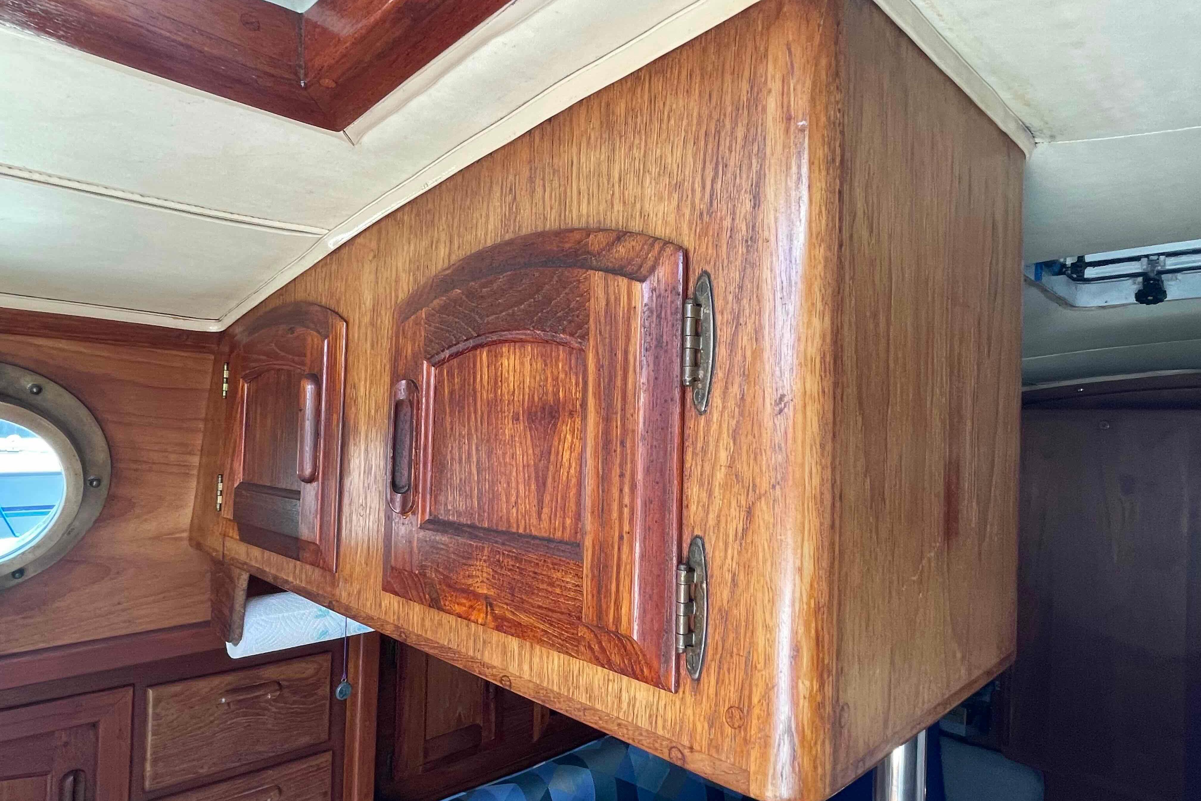 Wooden cabinetry inside a 1987 Pacific Seacraft 34 sailboat, showcasing classic nautical design.