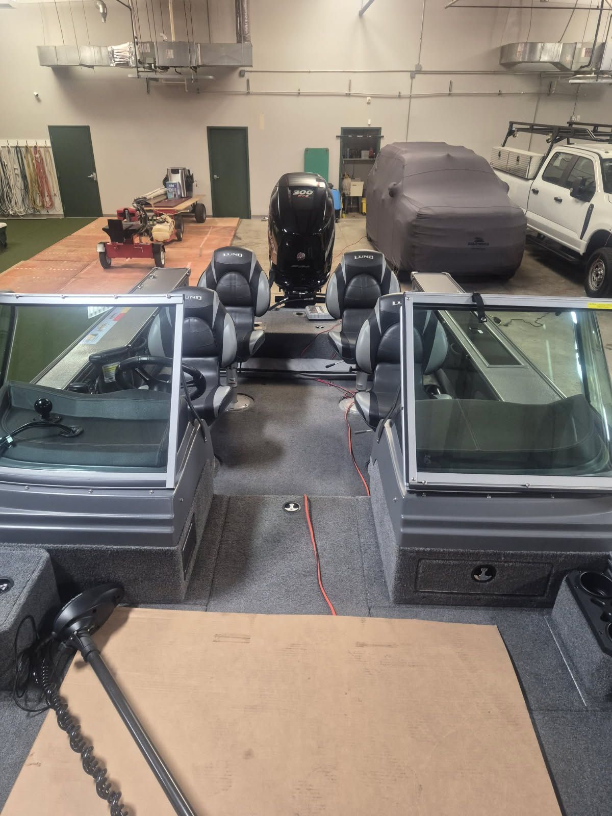 Interior view of a Lund Pro-V 2075 boat with seating and motor in a garage.