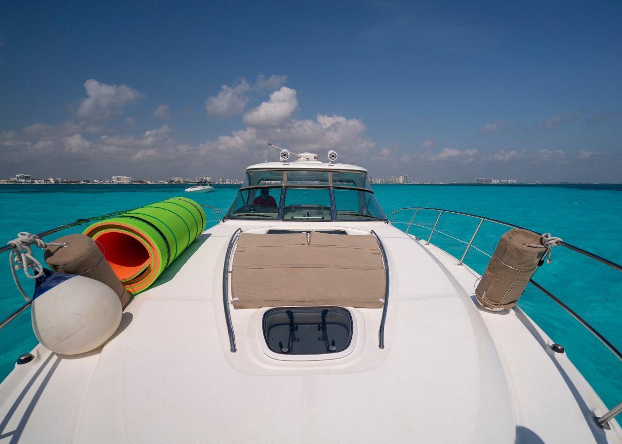 Sea Ray 440 Sundancer 2006 yacht on turquoise water, clear sky, colorful floats on deck.