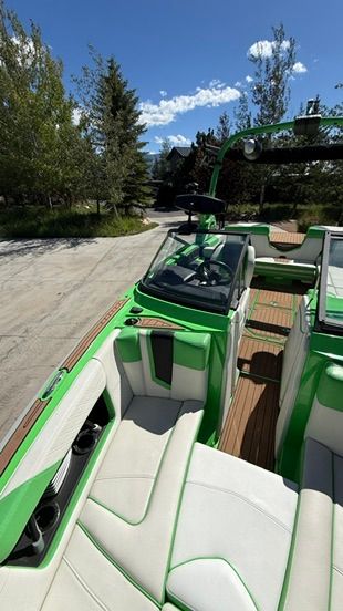 The image shows a green 2018 Super Air Nautique G23 boat with white seating.
