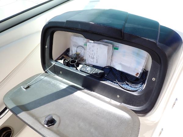 Storage compartment in a 2011 Chaparral 287 SSX boat, containing documents and accessories.
