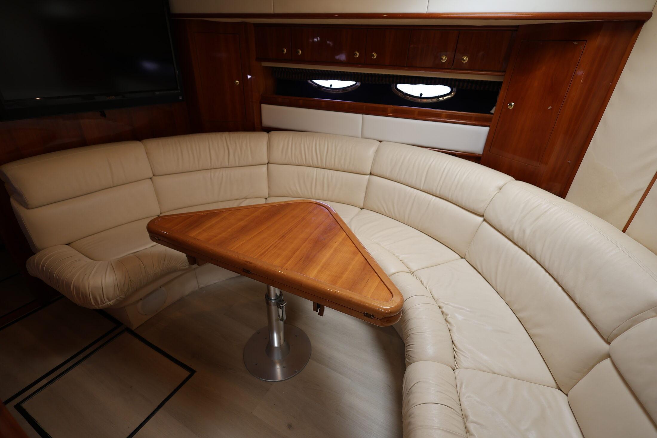 Luxurious interior of 1999 Neptunus 54 Express yacht with leather seating and wooden table.