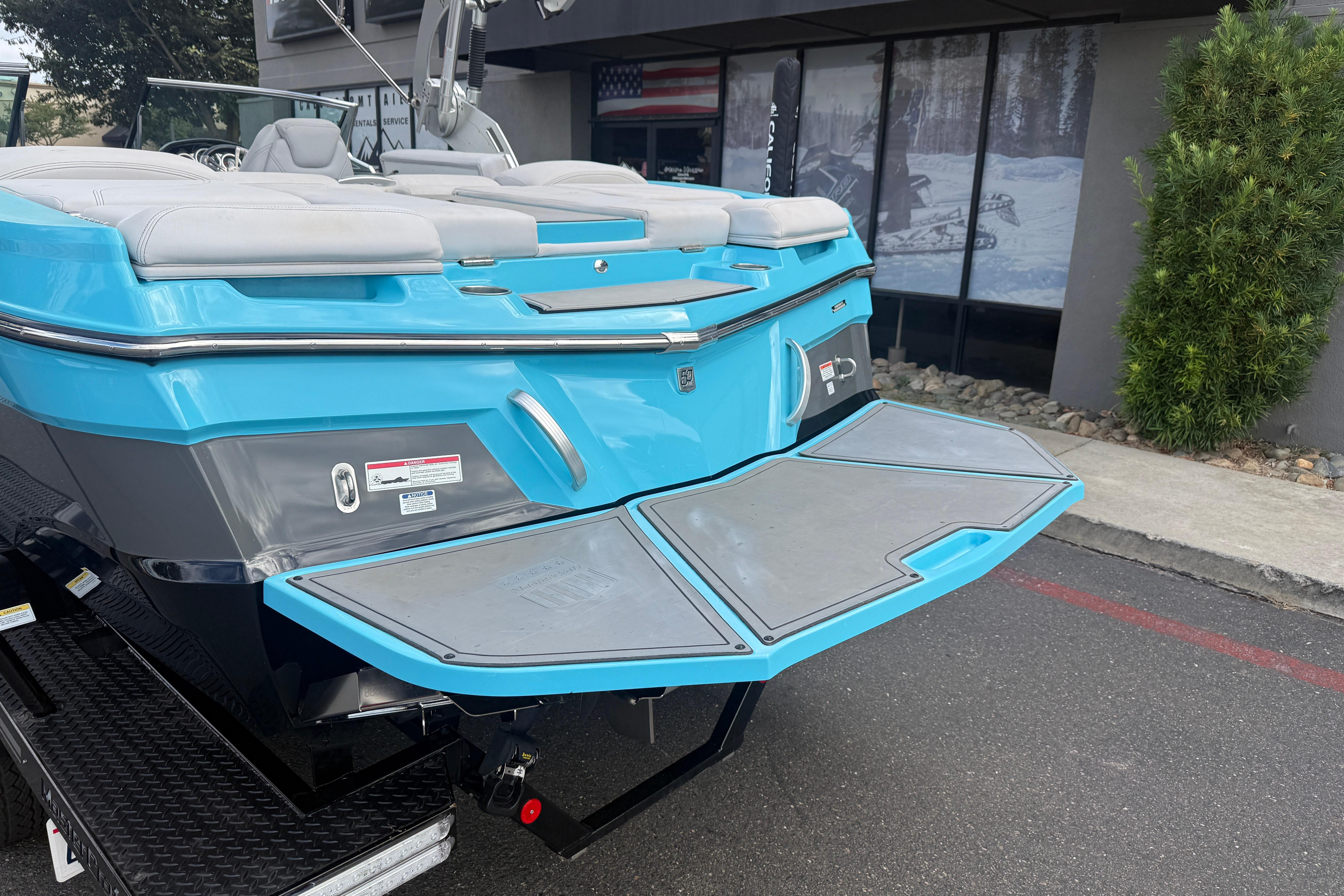 2018 MasterCraft XT21 boat with blue exterior and swim platform, parked outdoors.