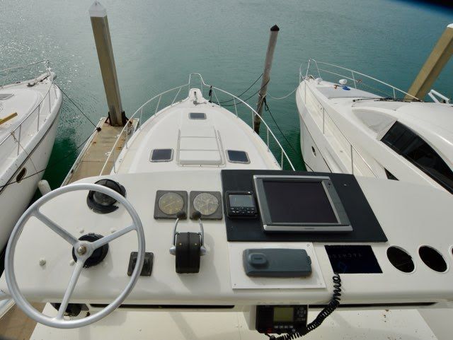 The cockpit of a 1994 Tiara Yachts 4300 Open, docked between two other boats.