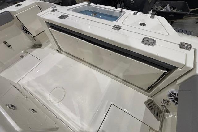 2026 Cobia 245 Center Console boat interior with storage compartments and seating area.