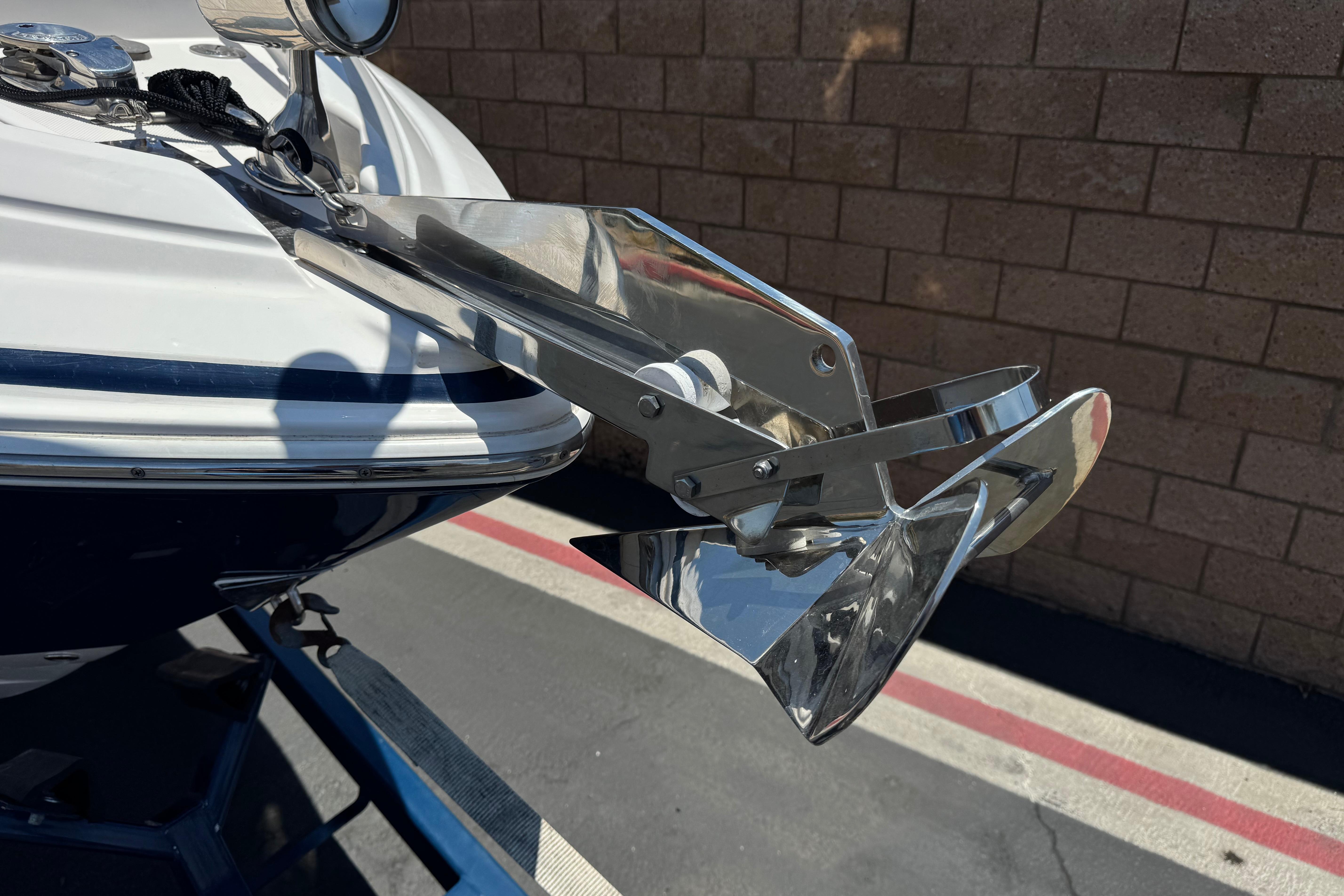 2013 Regal 28 Express boat anchor detail with chrome finish, parked on pavement.