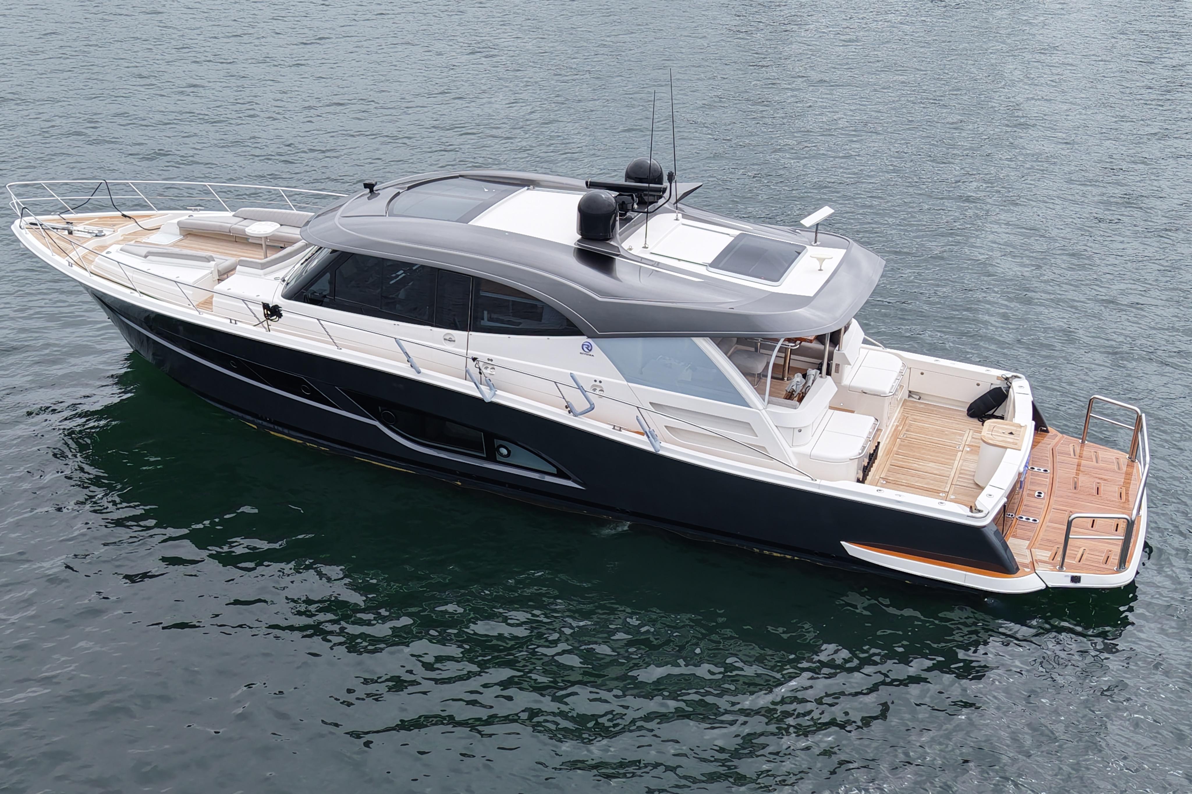 2023 Riviera 645 SUV luxury yacht on calm water, showcasing sleek design and spacious deck.